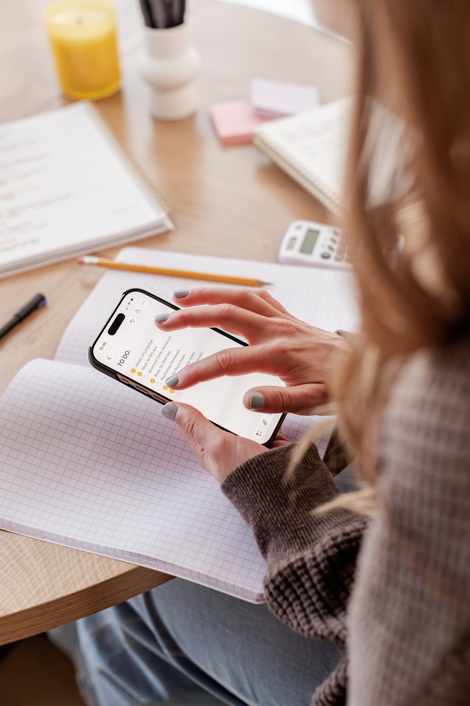 A stack of physical flashcards next to a phone open to a flashcard app for studying