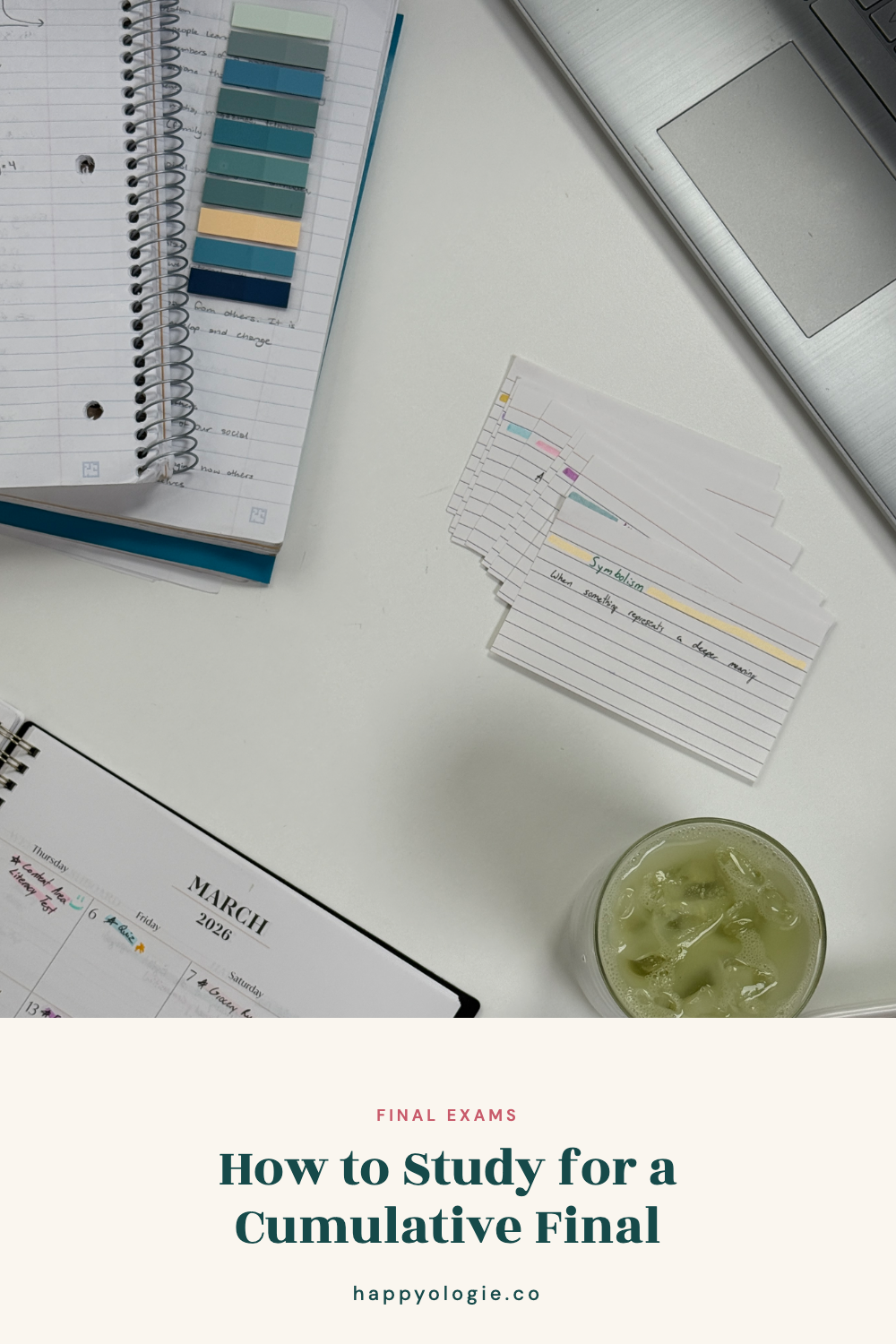 Study desk with a notebook, flashcards, laptop, planner, and iced green drink.