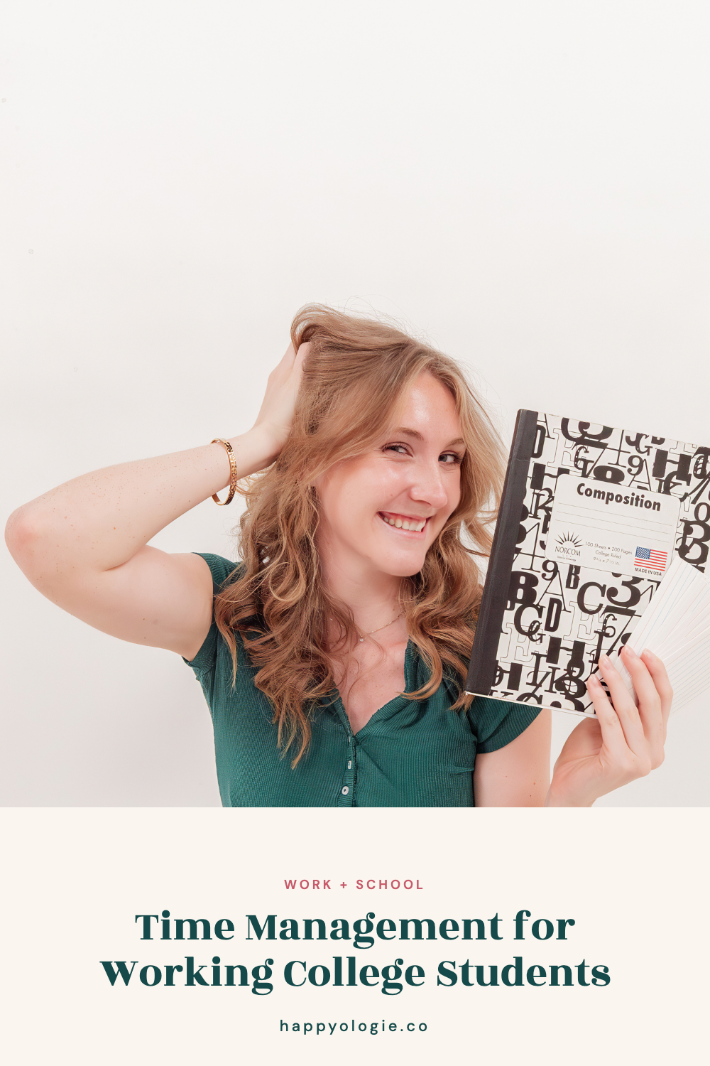College student smiling while holding a composition notebook.
