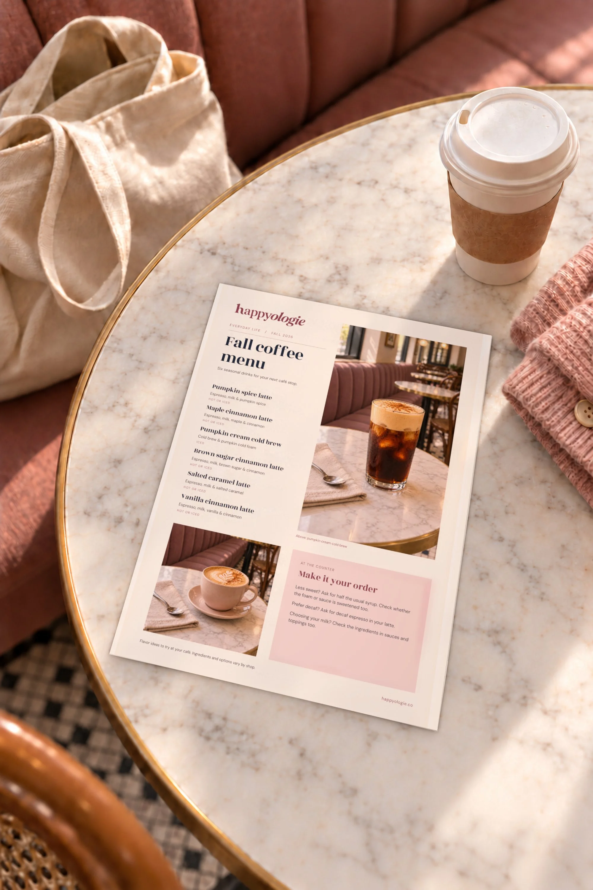 Happyologie Fall Coffee Menu facing the reader beside takeaway coffee, a tote and pink cardigan.