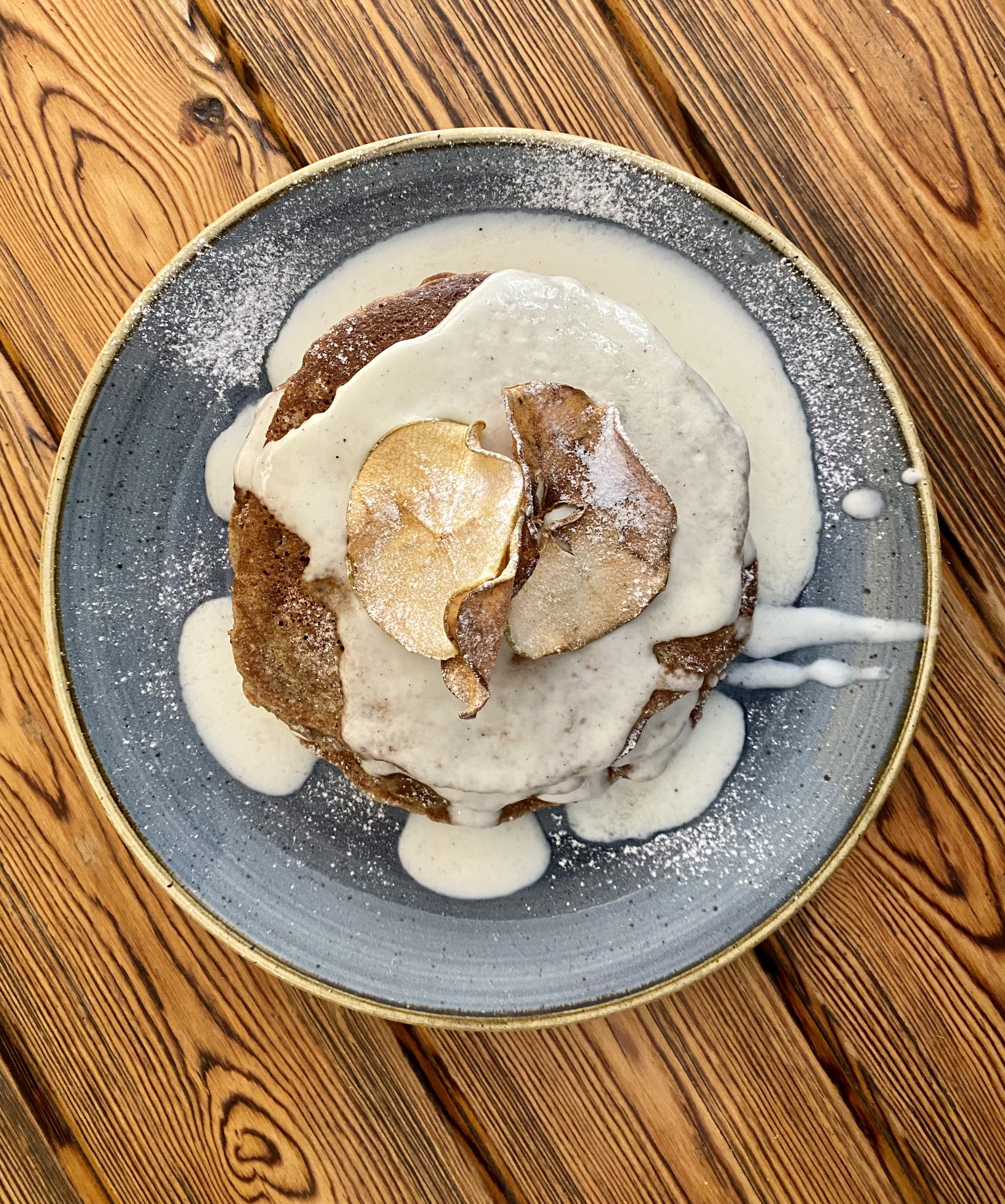 Postre de helado con crema, galleta, y rodajas de almendra en plato azul
