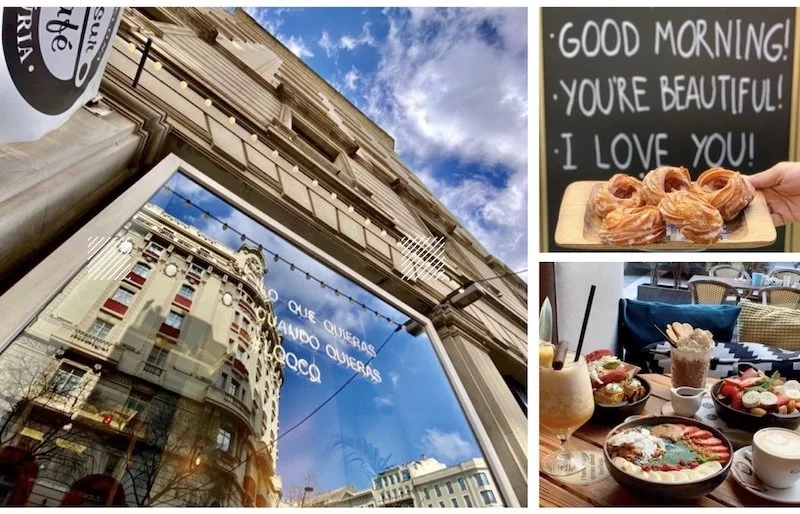 Foto de un edificio con cartel de vidrio que refleja otros edificios y el cielo azul con nubes. En la parte superior derecha, una pizarra con mensaje en inglés que dice 'Good morning! You're beautiful. I love you.'. Abajo a la derecha, una mesa con d