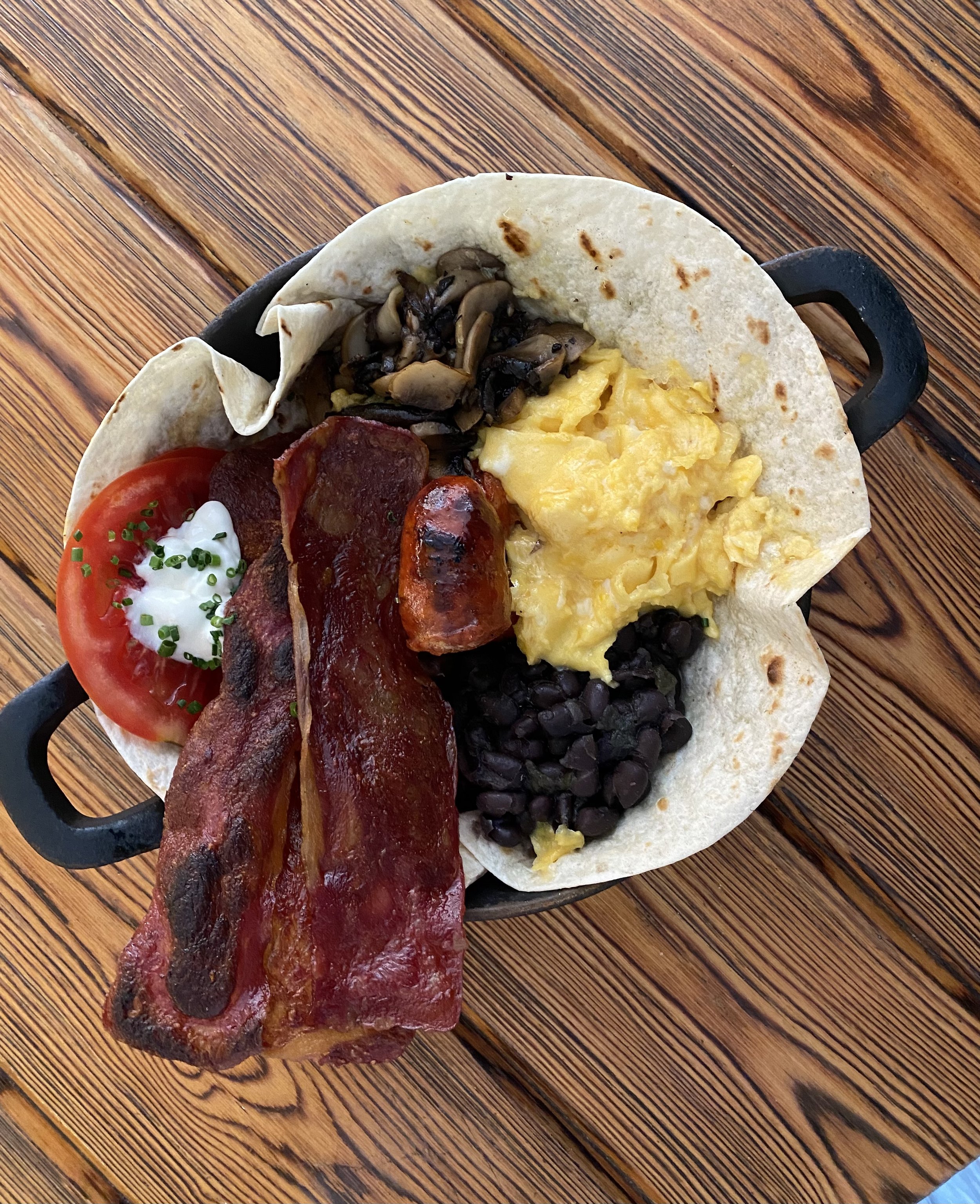 Tacos con jitomate, tocino, huevos revueltos, champiñones y frijoles negros.