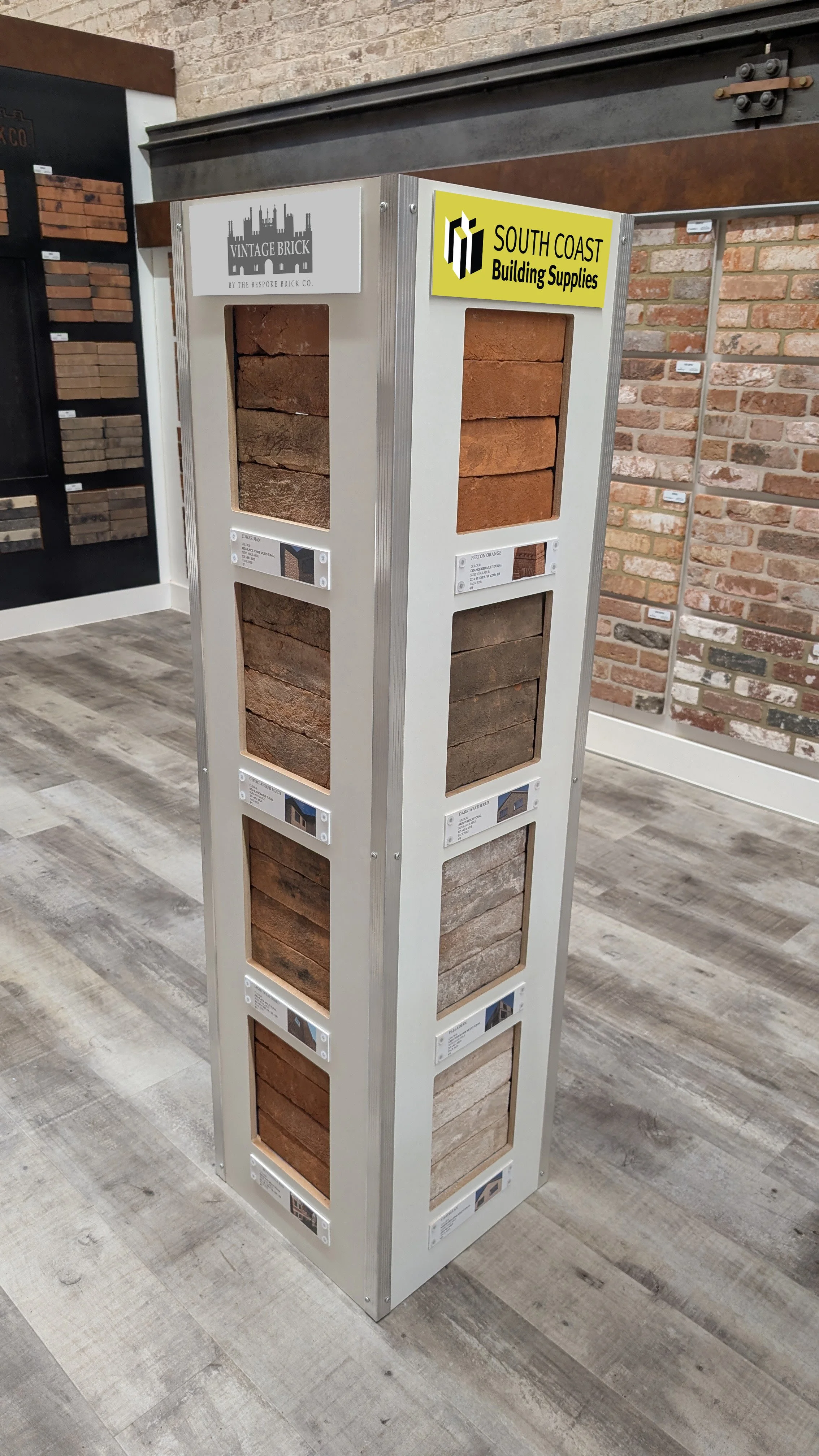 Display rack showing various bricks in a store, with brick sample labels and two logos at the top for Vintage Brick and South Coast Building Supplies.