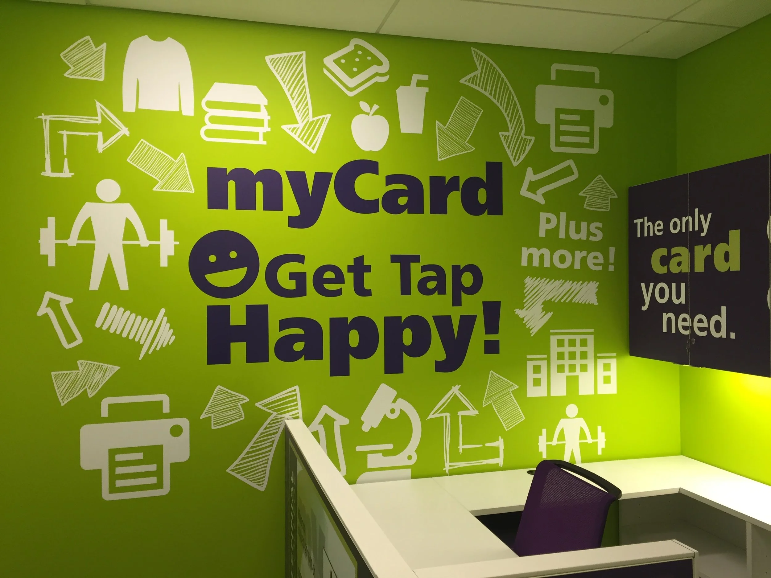 Green wall with large text reading 'myCard Get Tap Happy!' and various white icons and phrases related to cards, shopping, fitness, and office work.