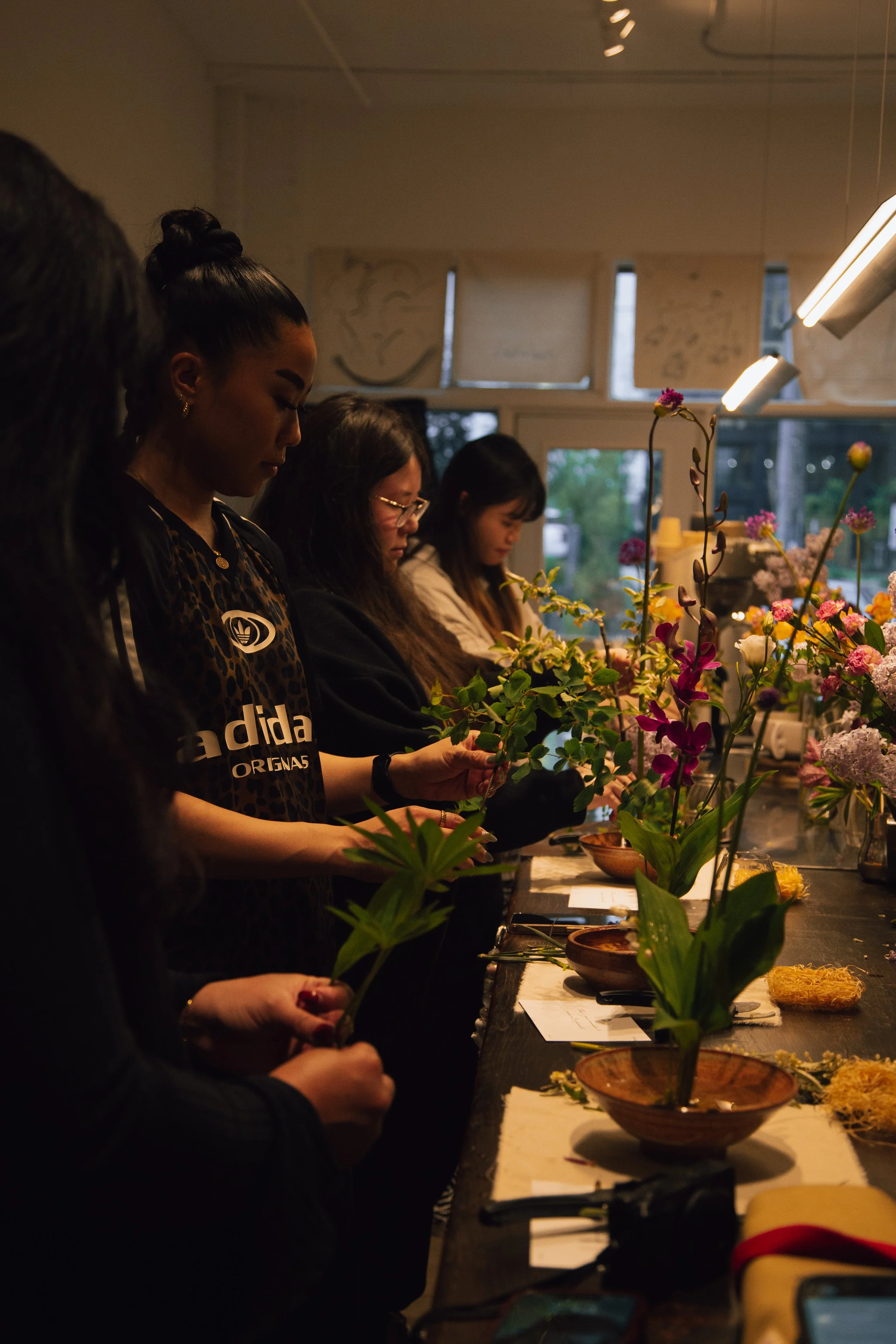 People working on floral arrangements at a flower workshop.