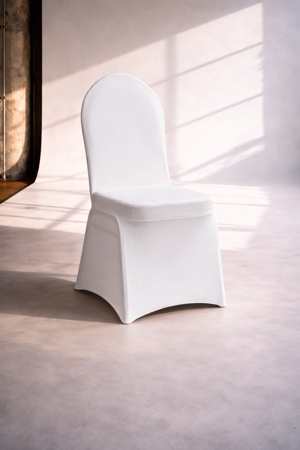 Ein weißer, stilvoller Stuhl mit hohem Rücken in einem hellen Raum mit Sonnenlicht, das durch Fenster Schatten wirft.