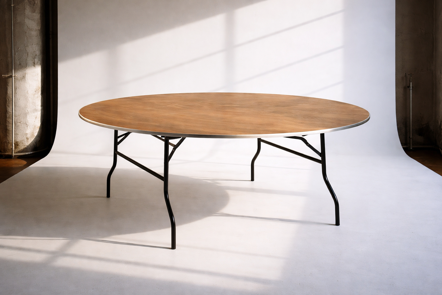 Runder Esstisch mit Holzplatte und schwarzen Metallbeinen in einem Raum mit natürlichem Licht.