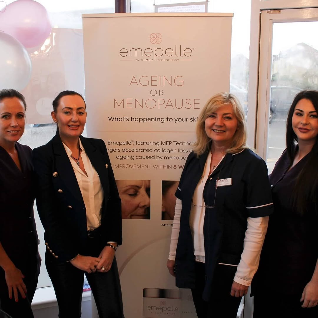 Four women standing in front of a promotional banner for Emepelle, a skincare product targeting aging or menopause, at an indoor event.