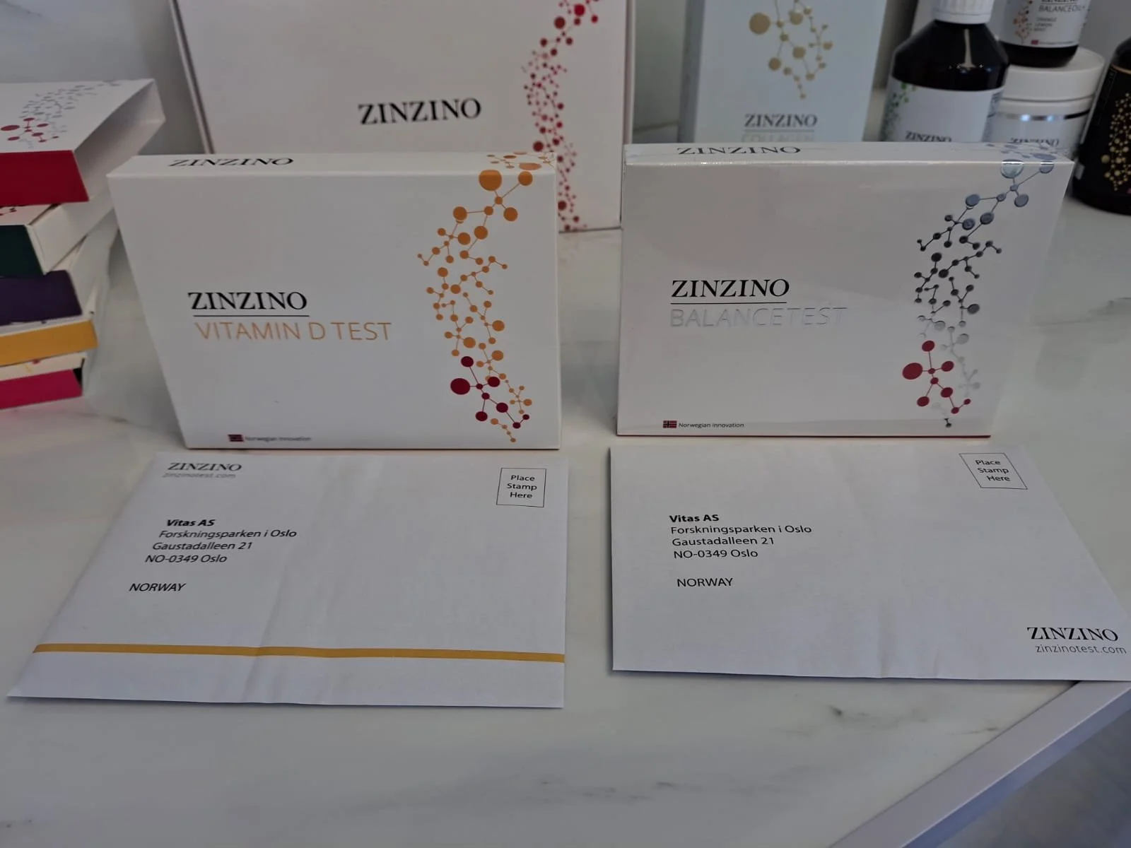 Boxes of ZINZINO vitamin D and balance test kits on a white surface with envelopes in front of them.