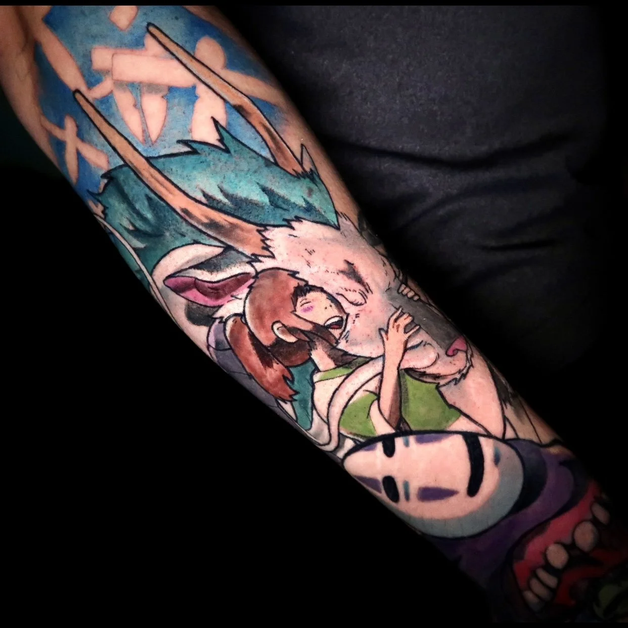 Colorful tattoo on person's arm depicting a cartoon scene with a rabbit and a girl.