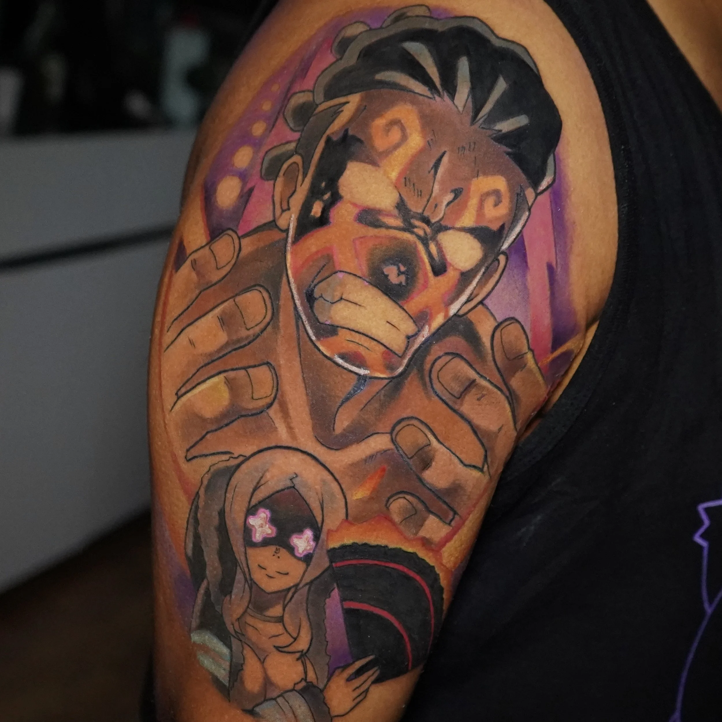 Tattoo of a man and a girl on a person's arm. The man has dreadlocks, sunglasses, and a large hand gesture, while the girl has long hair, closed eyes, and pink bows over her glasses.