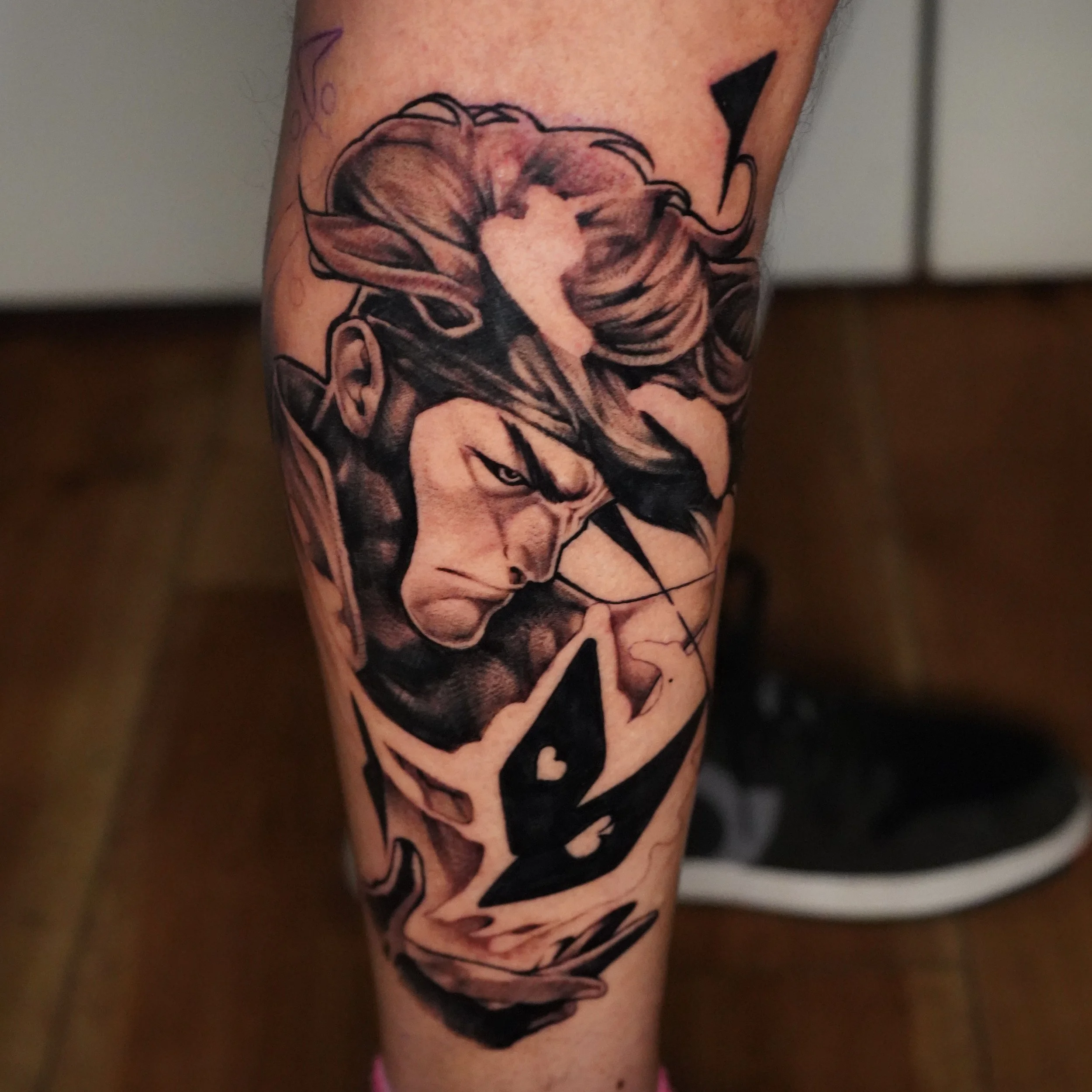 Tattoo of a woman with glasses and a serious expression, holding a bow and arrow, with graffiti-style elements and abstract shapes.