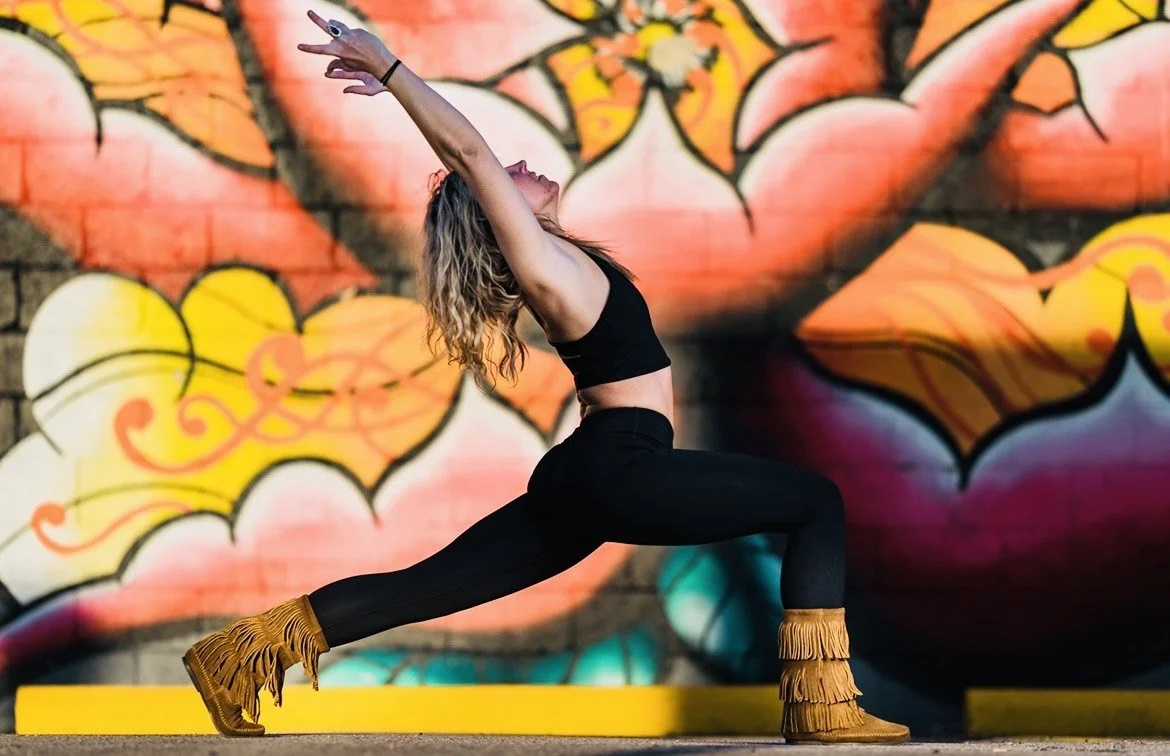 Yoga instructor posing against mural wall