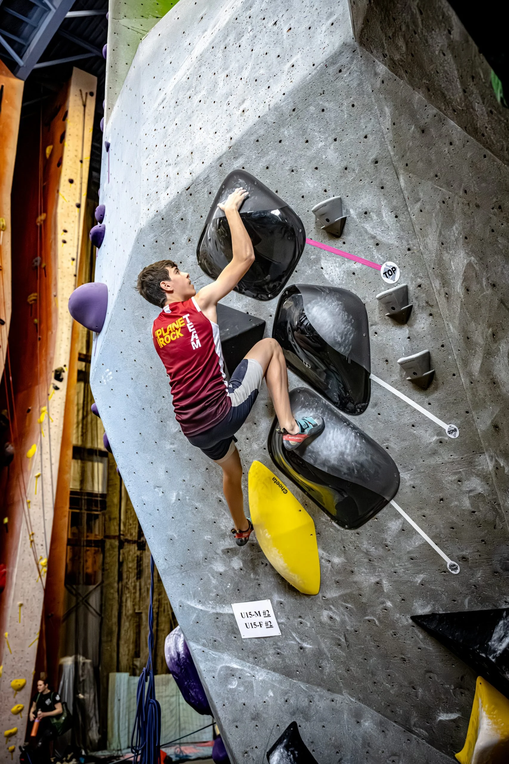 Youth team member climbing bouldering wall