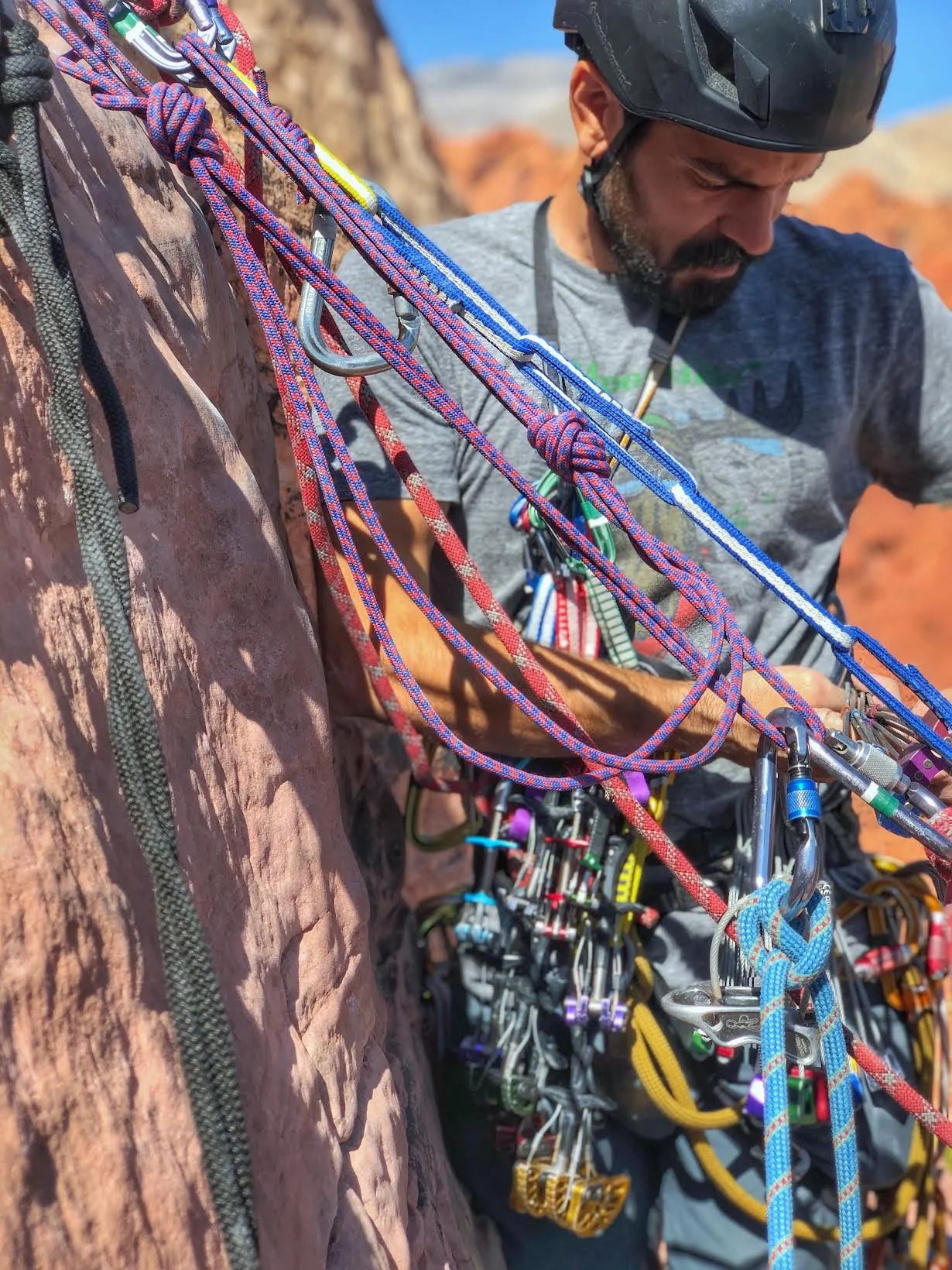 Rock climber on outdoor wall anchor showing gear and ropes