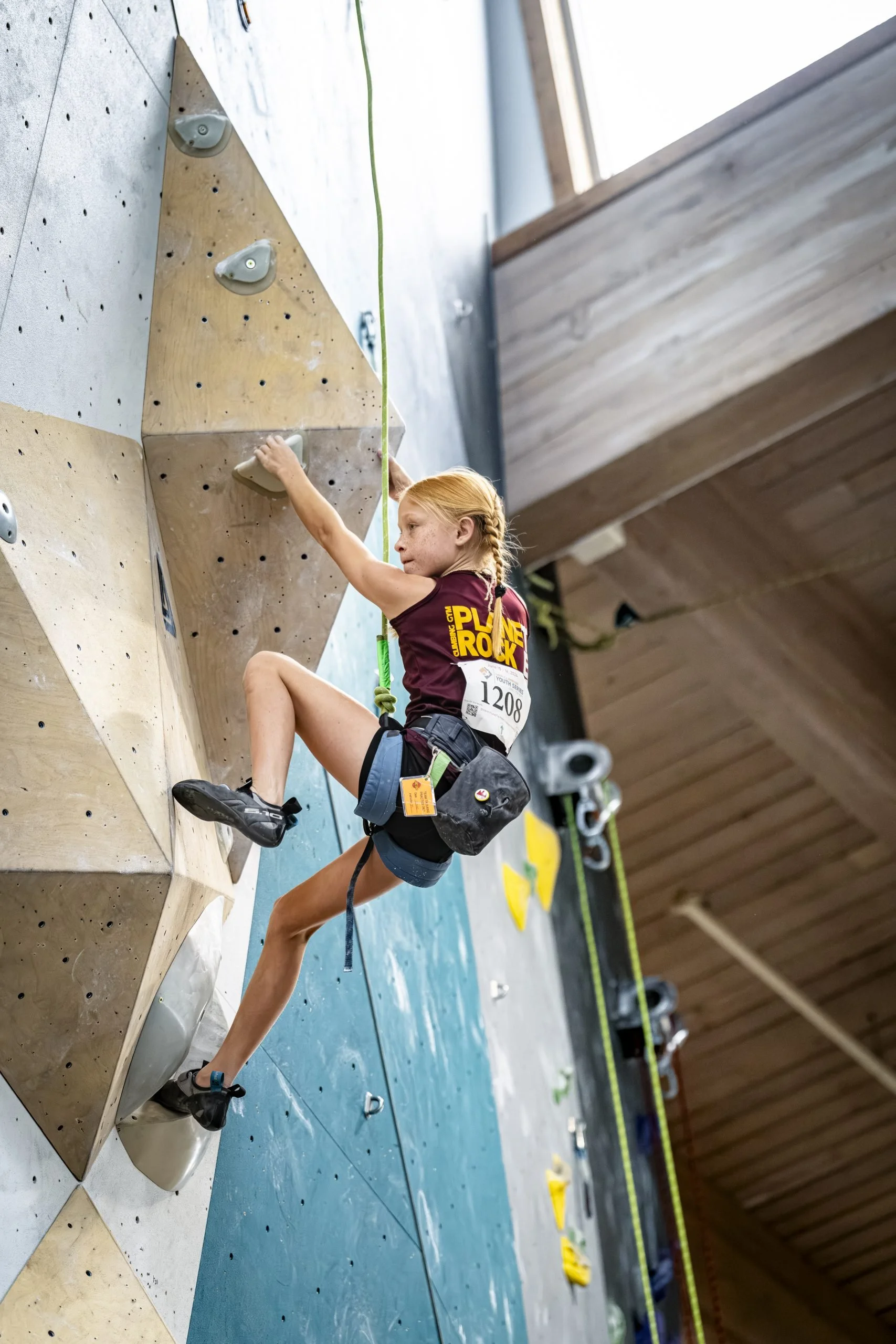Youth team member climbing wall on top rope