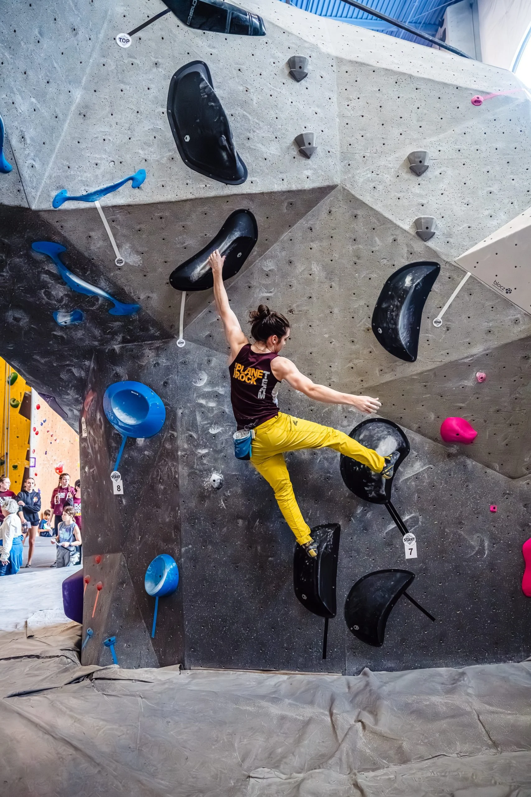 Youth team member climbing bouldering wall