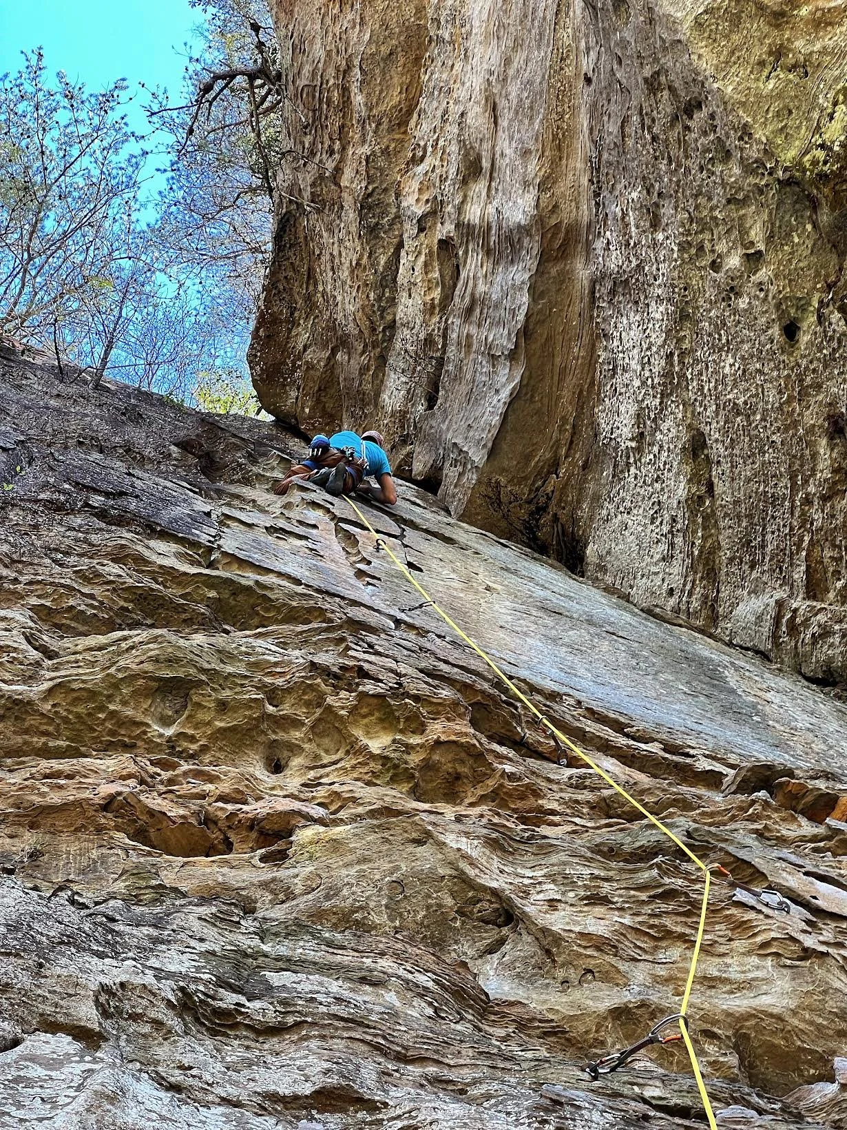 Rock climber lead climbing on outdoor rock wall in the Red River Gorge