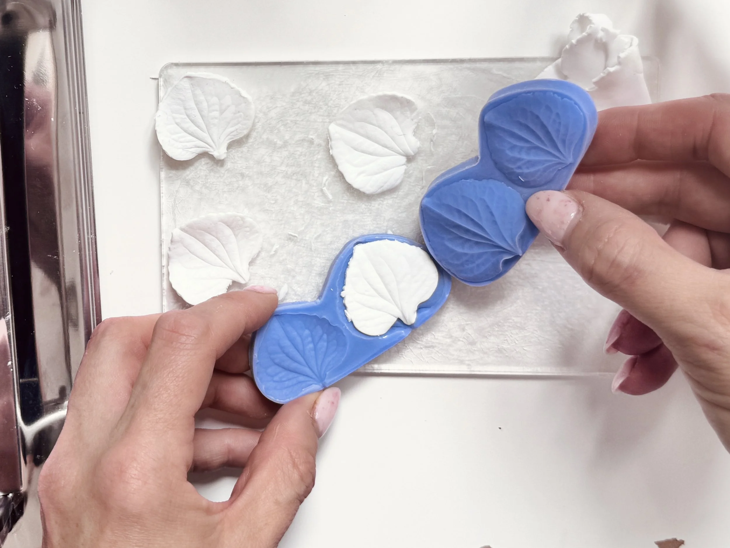 Close-up of bridal accessory designer Jen Gilbert sculpting clay flower petals by hand as part of a bespoke bridal accessory design process.