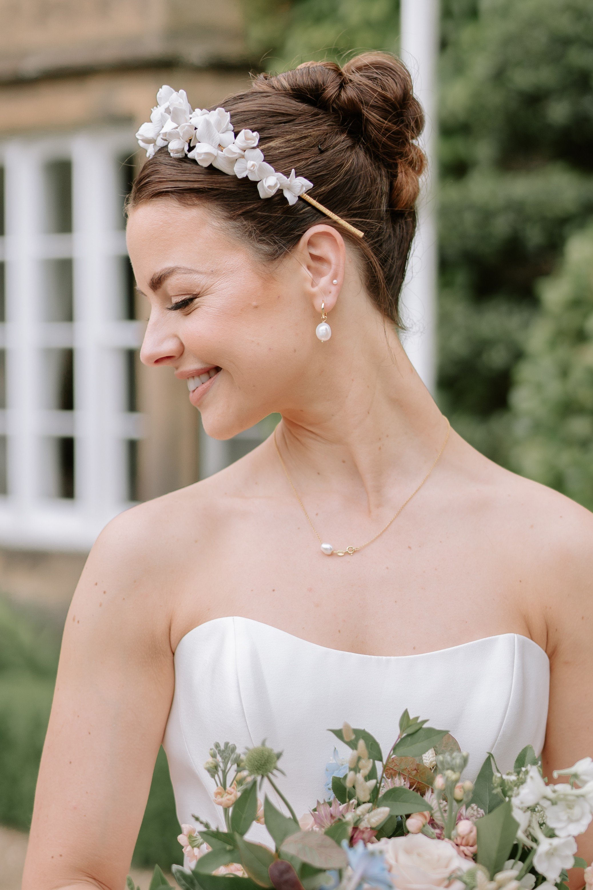 Bride wearing a petite floral bridal crown featuring handcrafted clay iris flowers, designer couture wedding crown.