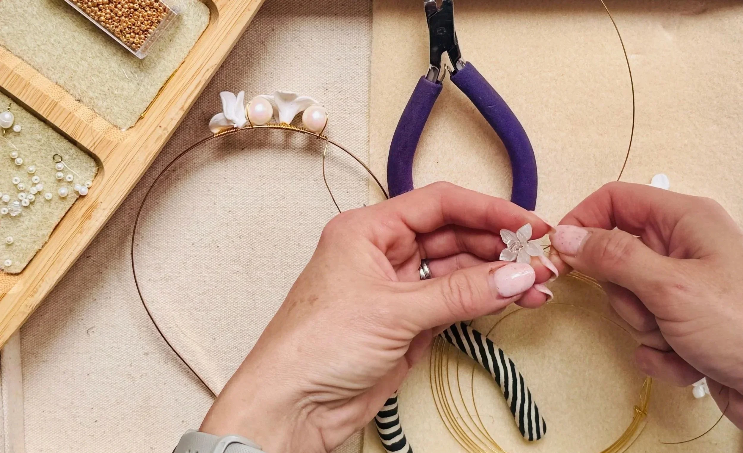 Close-up of bespoke bridal headpiece design in progress, featuring gold wire, pearls and handcrafted floral details.