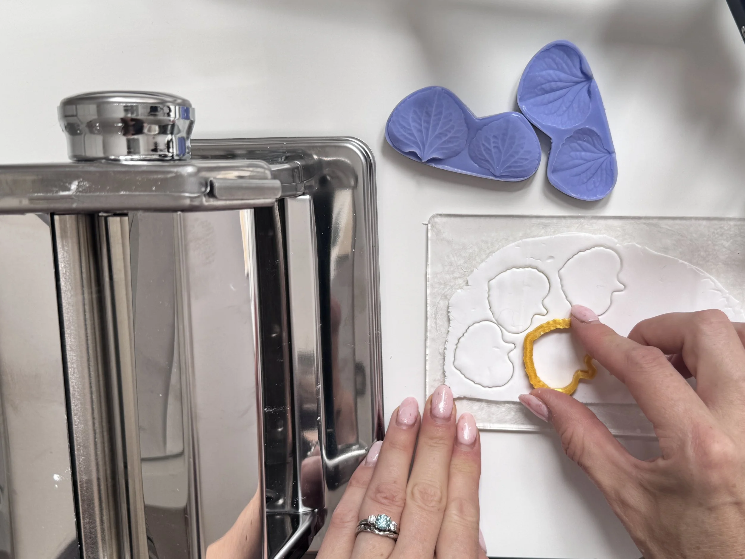 Behind-the-scenes view of clay flowers being formed petal by petal for handcrafted bridal headpieces.