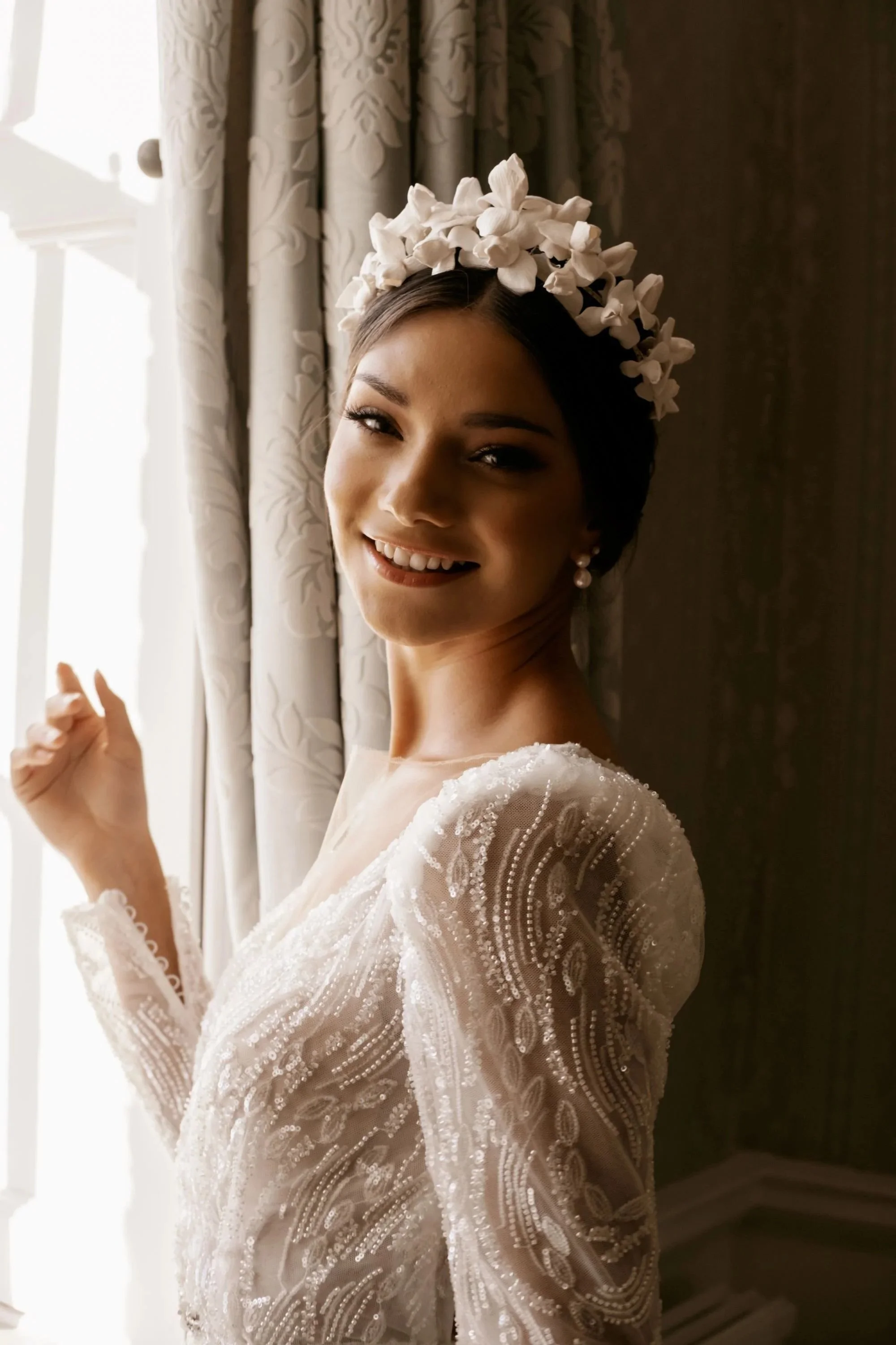 Bride wearing a handcrafted floral bridal headpiece by Jen Gilbert, featuring delicate white clay flowers styled with a modern wedding dress.