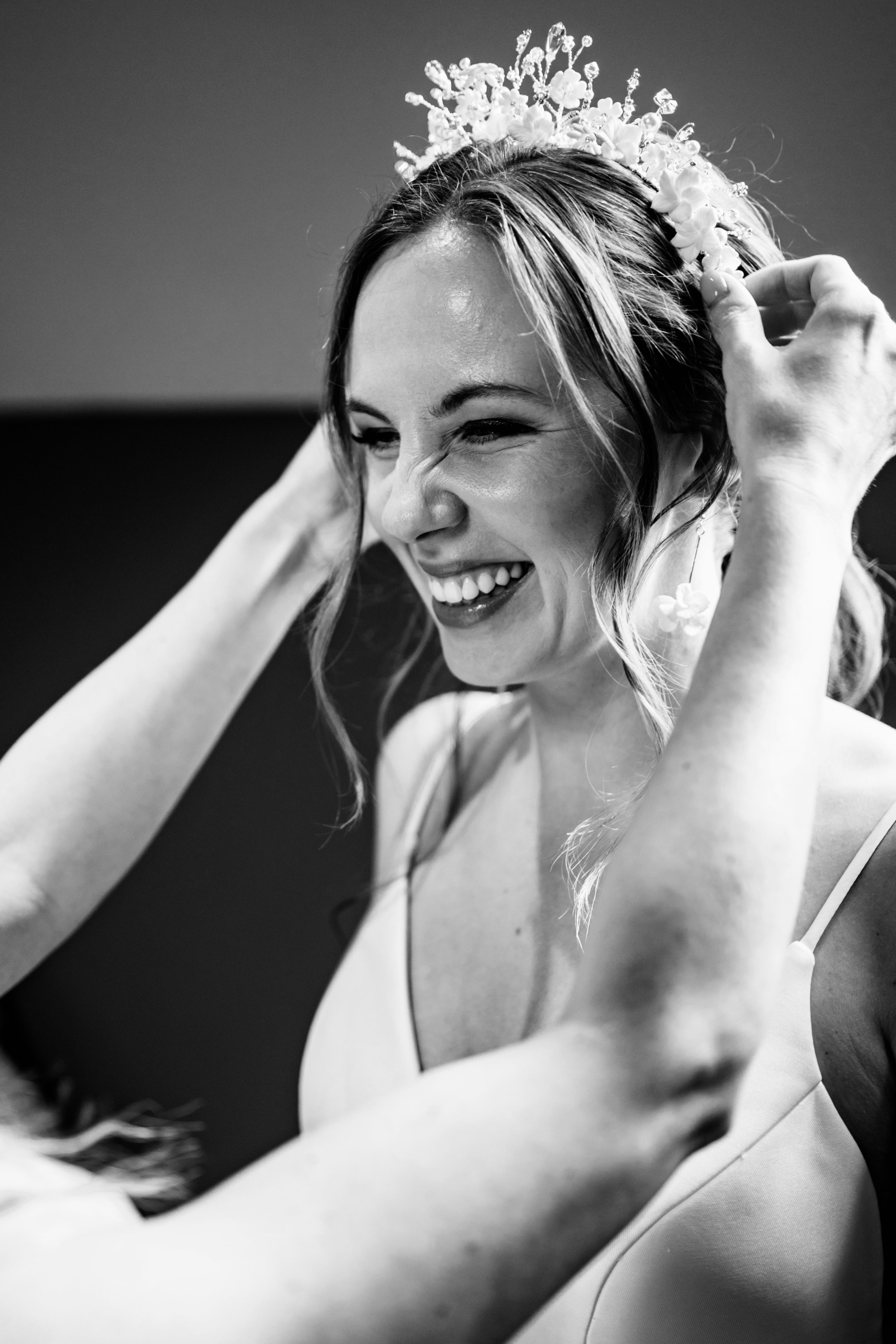 Bride wearing a designer bridal crown with floral detailing, showcasing a couture bridal accessory during wedding preparations.
