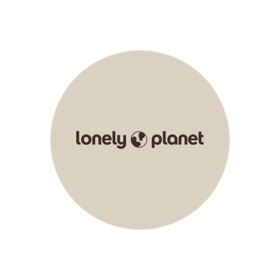A circular logo with the text 'lonely planet' and a small globe icon in between, on a cream background.
