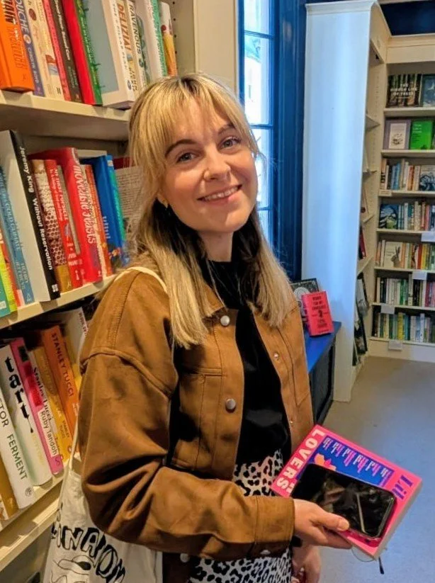 Woman next to a shelf full of books