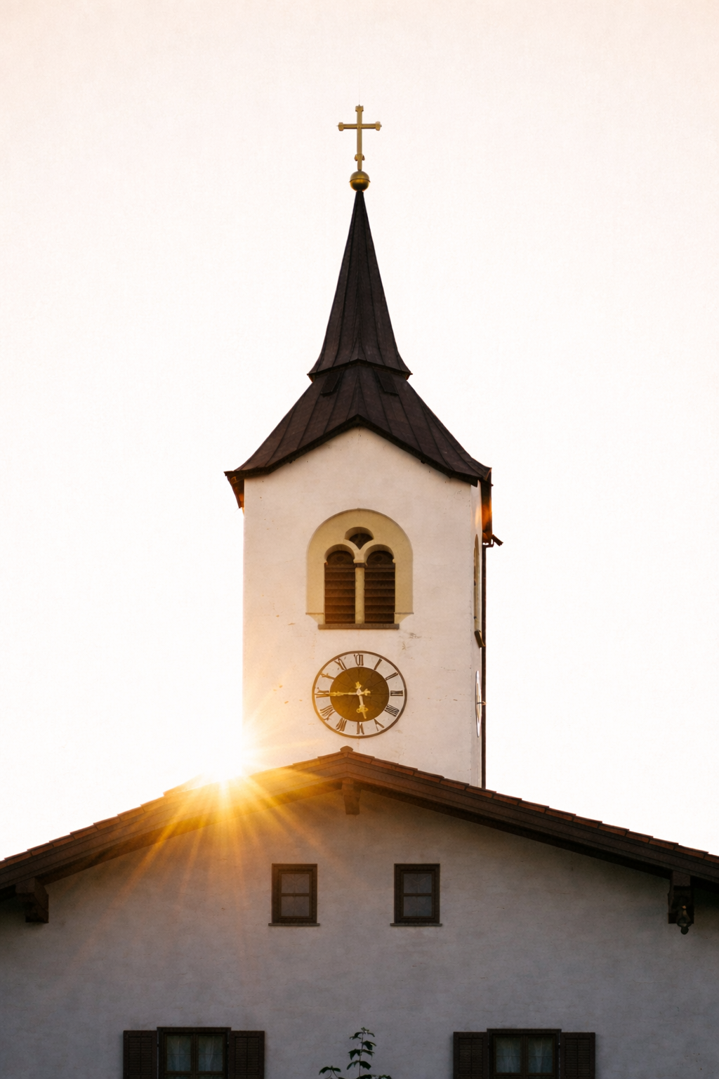 Church steeple with a cross at the top, sunset glow, and a clock on the building below.
