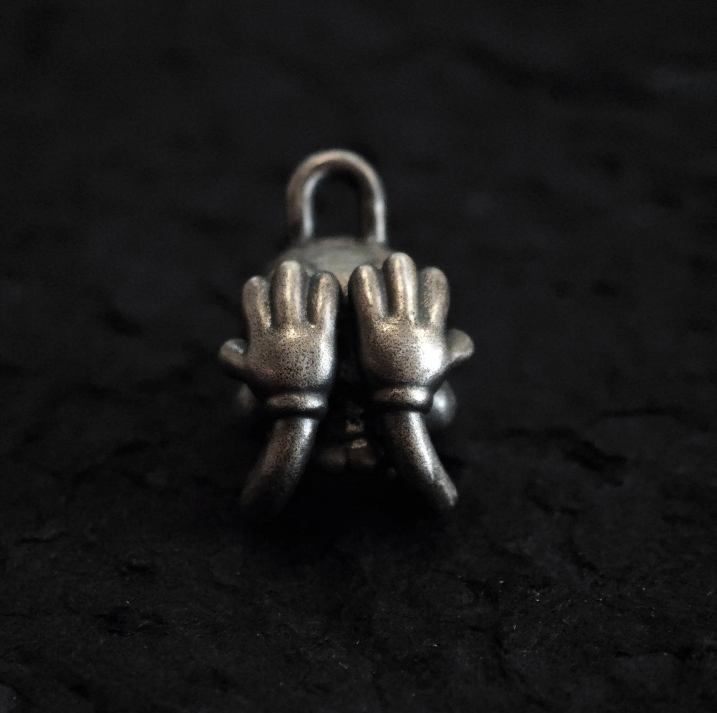 Xia Penghao BONE BUD THREE SENSES VEIL Pendant - Flat lay front view showing hands covering eyes