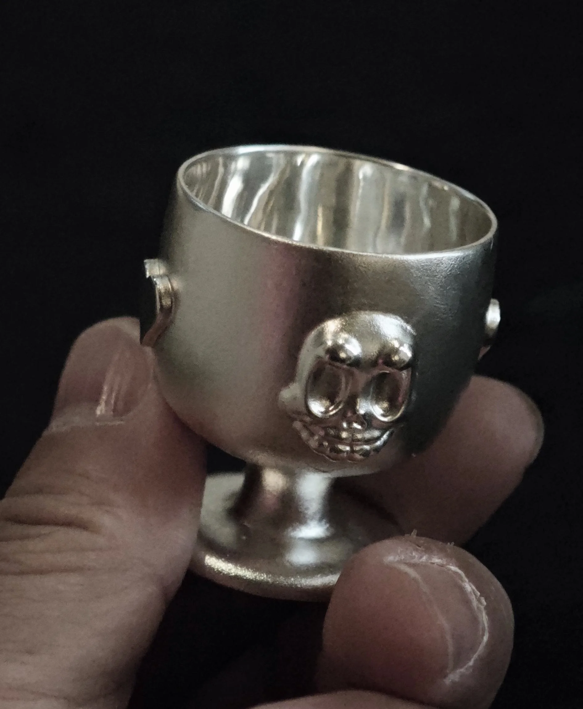 Xia Penghao BONE BUD HEART CUP - Handheld view showing BONE BUD skull relief on cup body