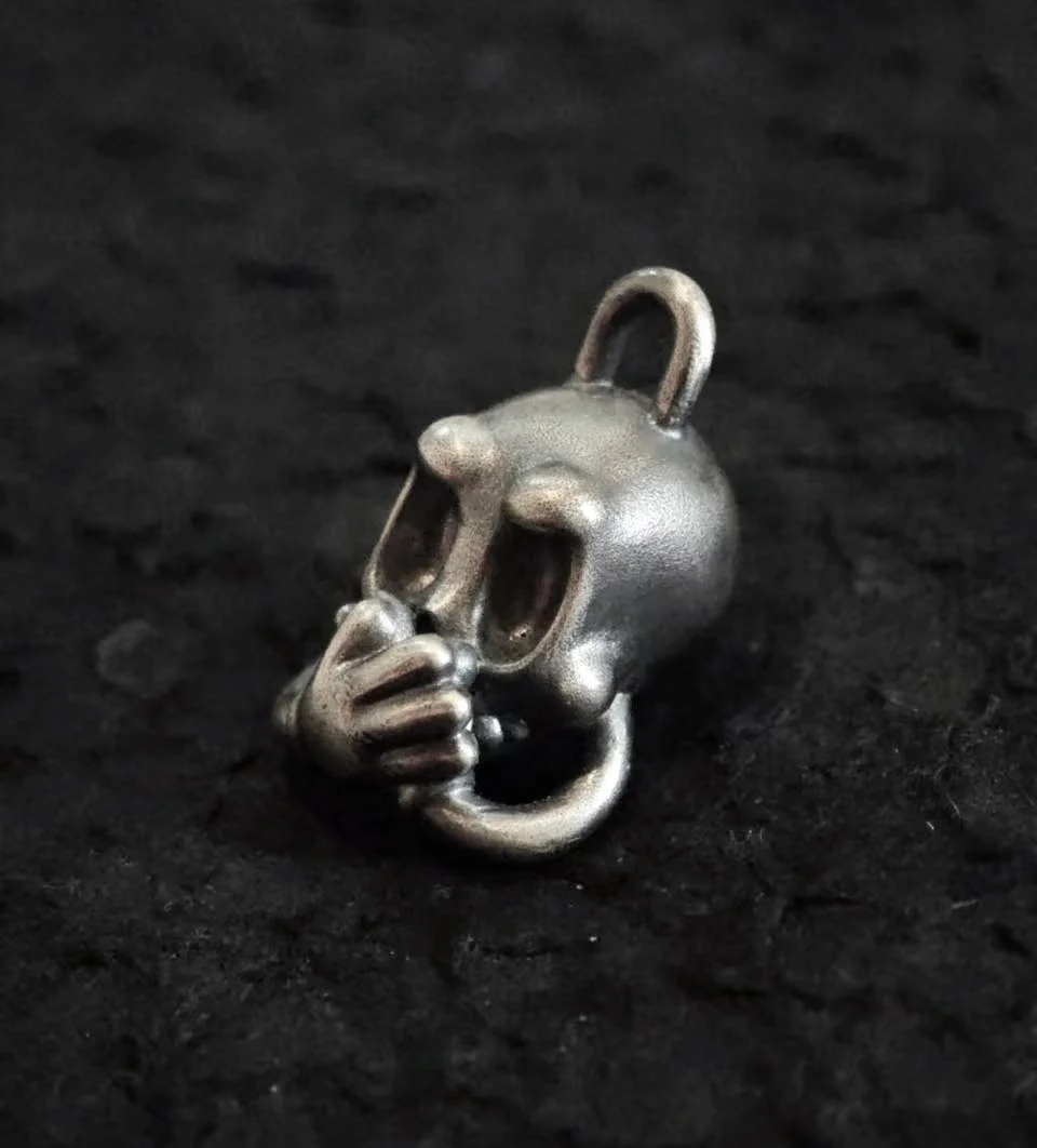 Xia Penghao BONE BUD THREE SENSES GAG Pendant - Angled side profile on tabletop