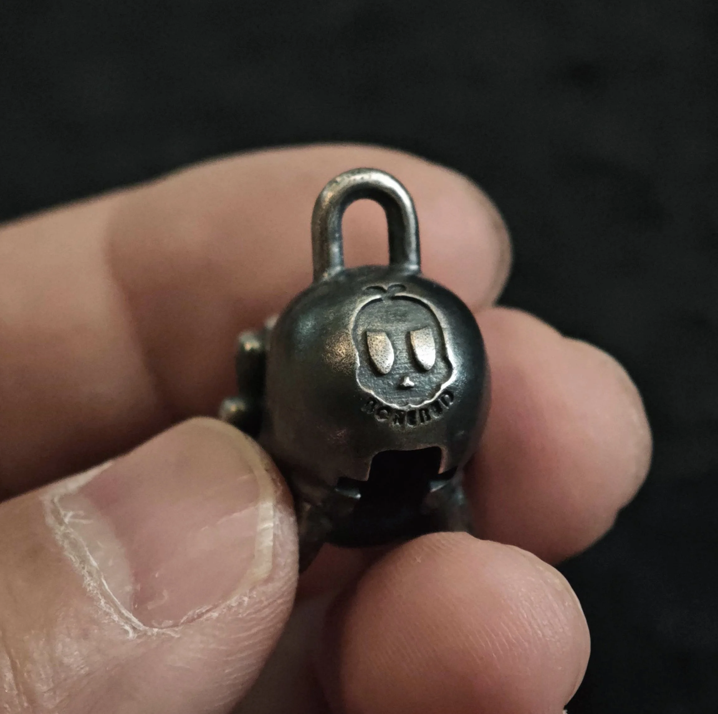 Xia Penghao BONE BUD THREE SENSES VEIL Pendant - Handheld view showing BONE BUD logo on reverse
