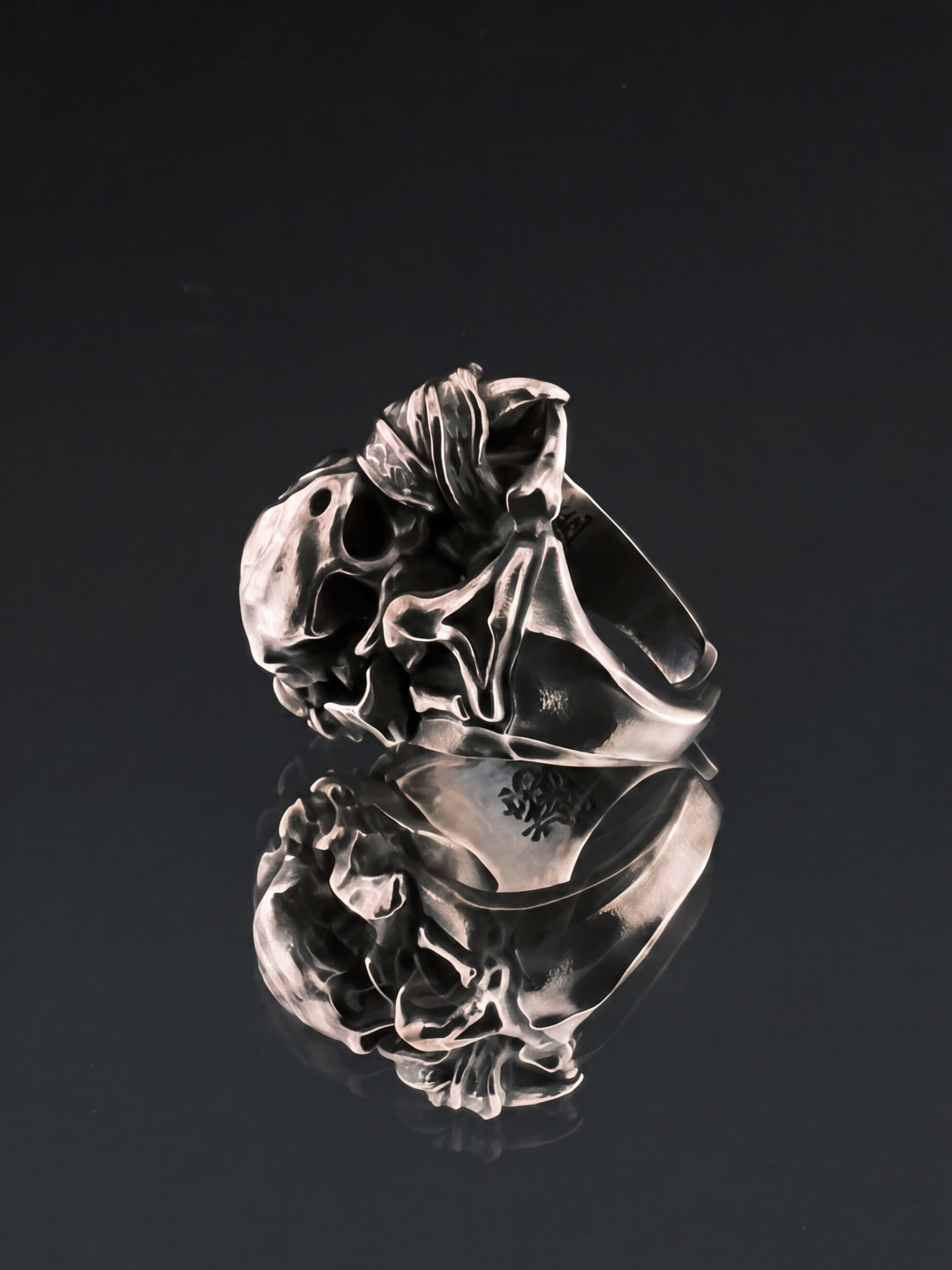 Liangshui Forge Three No Birds Muted Beak Ring - Lying on mirrored surface, side profile showing skull and band