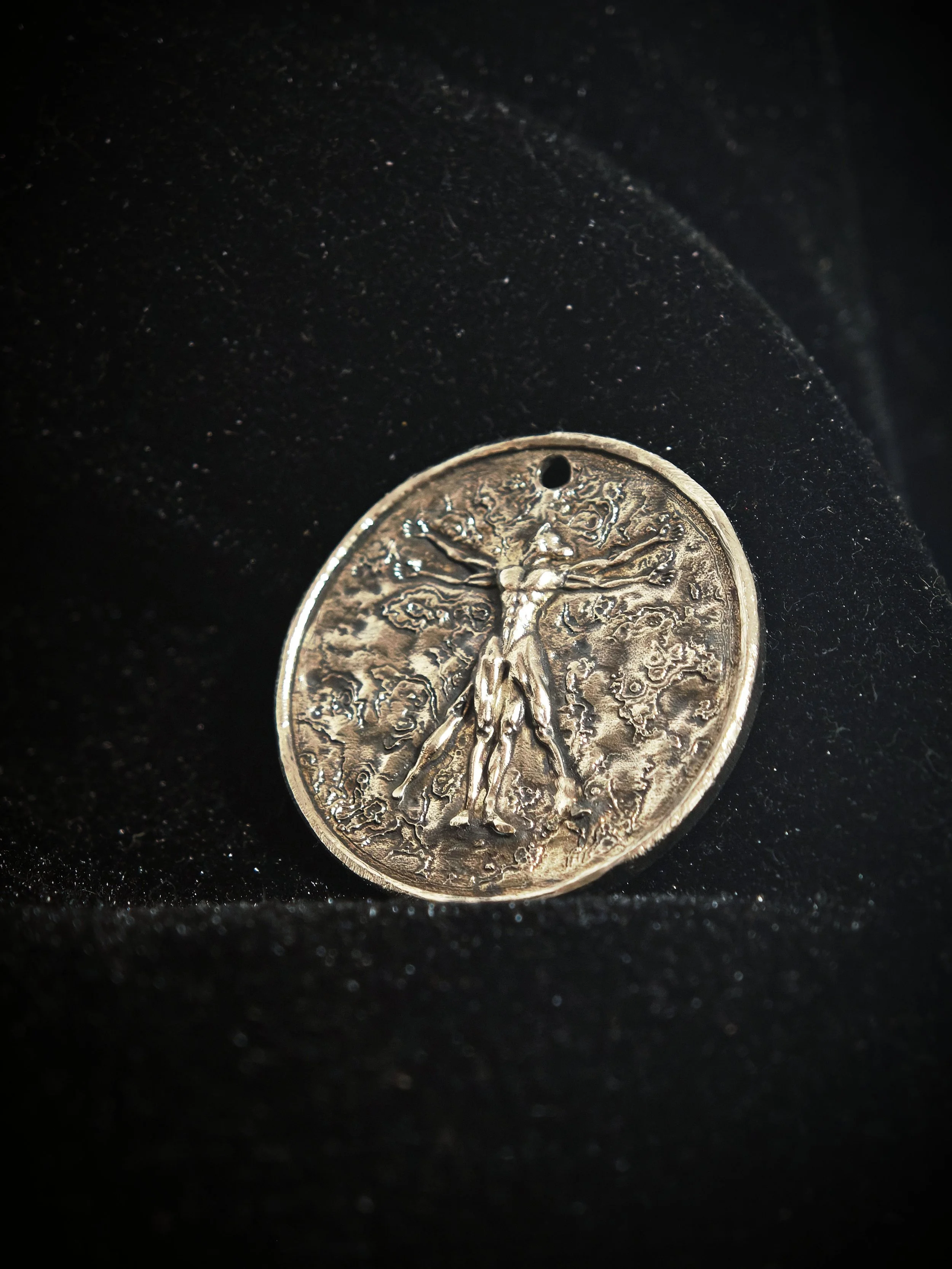 DHG Y2 Vitruvian Hound Medallion - Front view showing hound-headed Vitruvian figure within circle and square