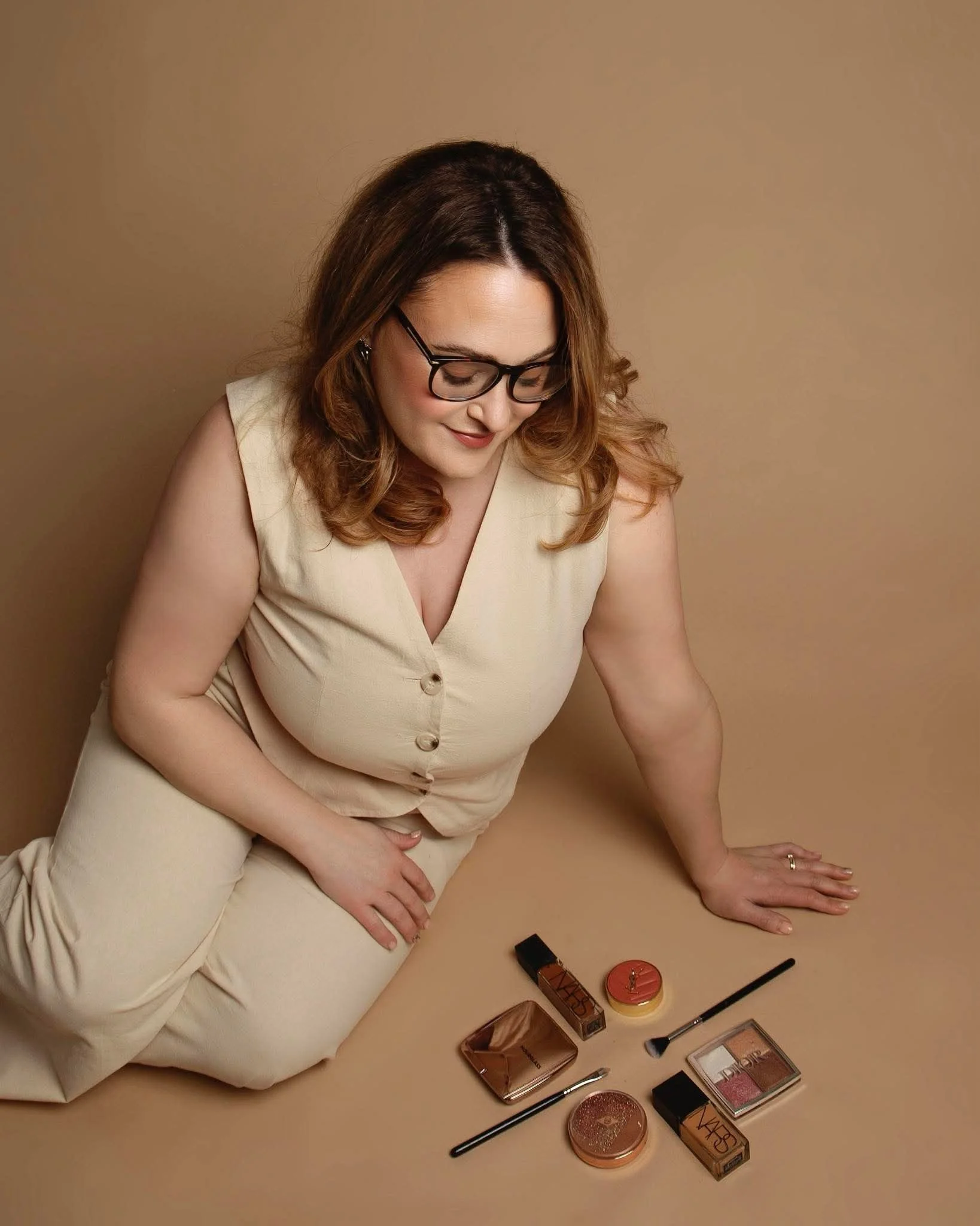 Makeup artist looking down at makeup products and brushes