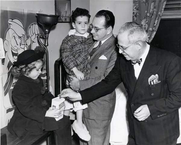 During the polio epidemic, two of Max Fleischer’s grandchildren were hospitalized with polio. In 1947 while the children were patients at Knickerbocker Hospital, Max donates to the March of Dimes. Nancy Drury, holding the box, is the March of Dimes P