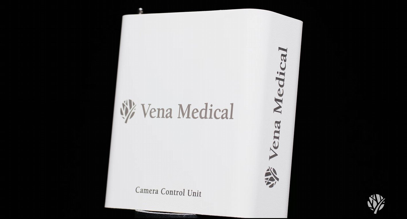 A white rectangular device with gray text that reads 'Vena Medical' and 'Camera Control Unit' against a black background.