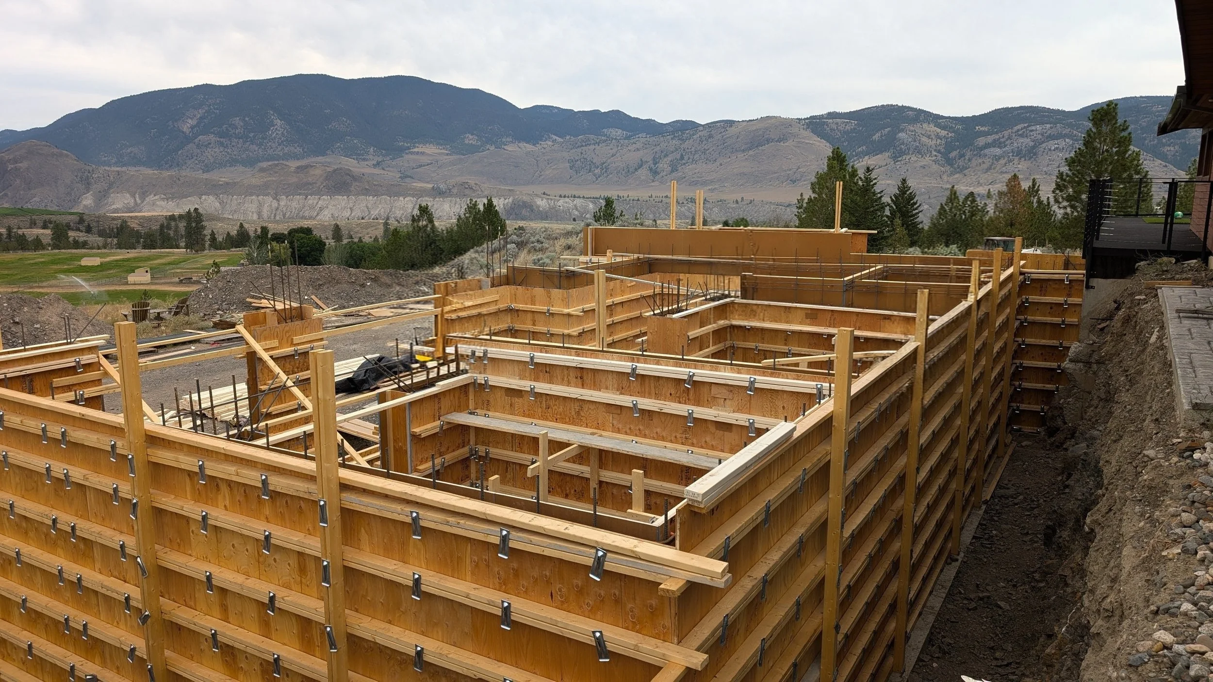 Concrete foundation forming for a custom home build in Kamloops, BC, showing cone tie forming for a suspended slab over top