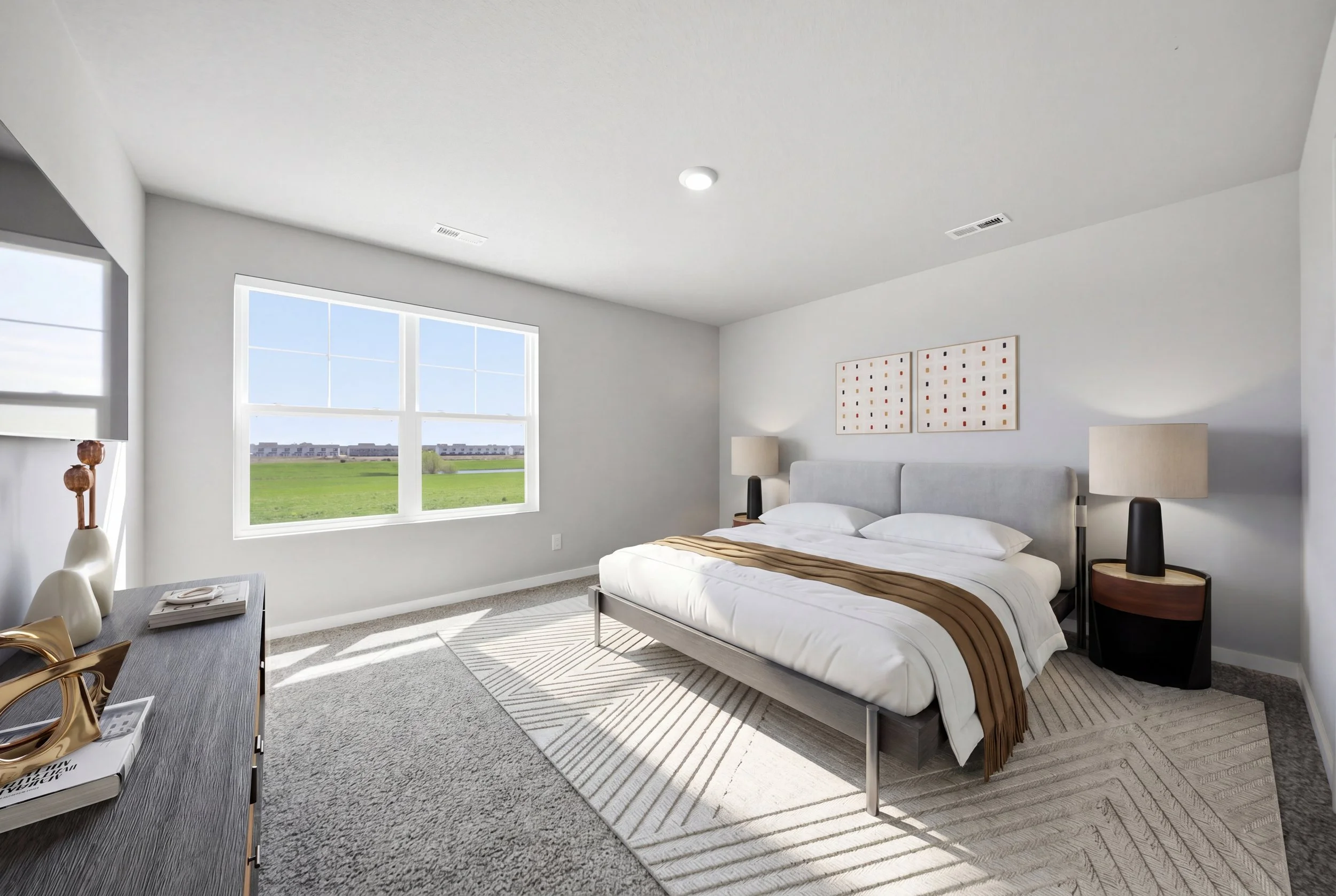 Real estate virtual staging photography of a modern bedroom with a large bed, two bedside tables with lamps, abstract artwork, a window showing an outdoor field, a dresser with decorative items, and a beige rug.