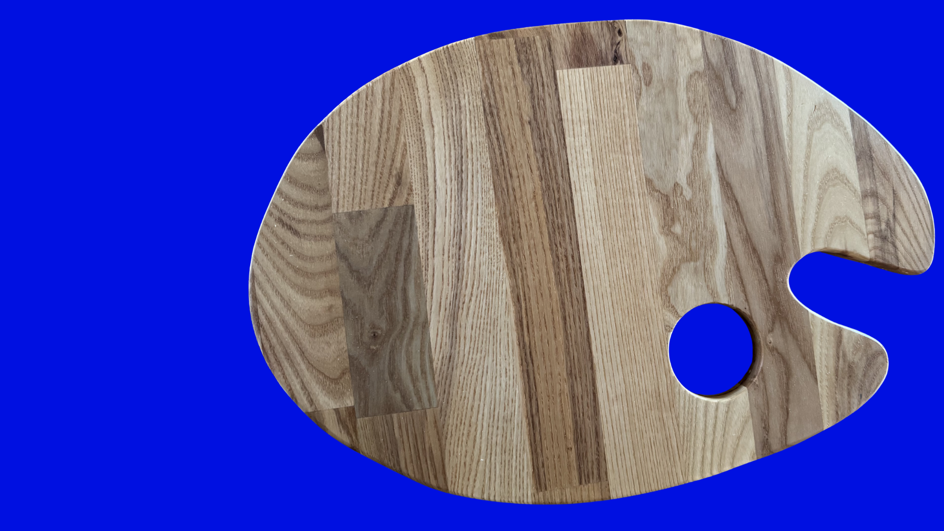 Wooden paint palette with a hole for an artist's thumb on a blue background.