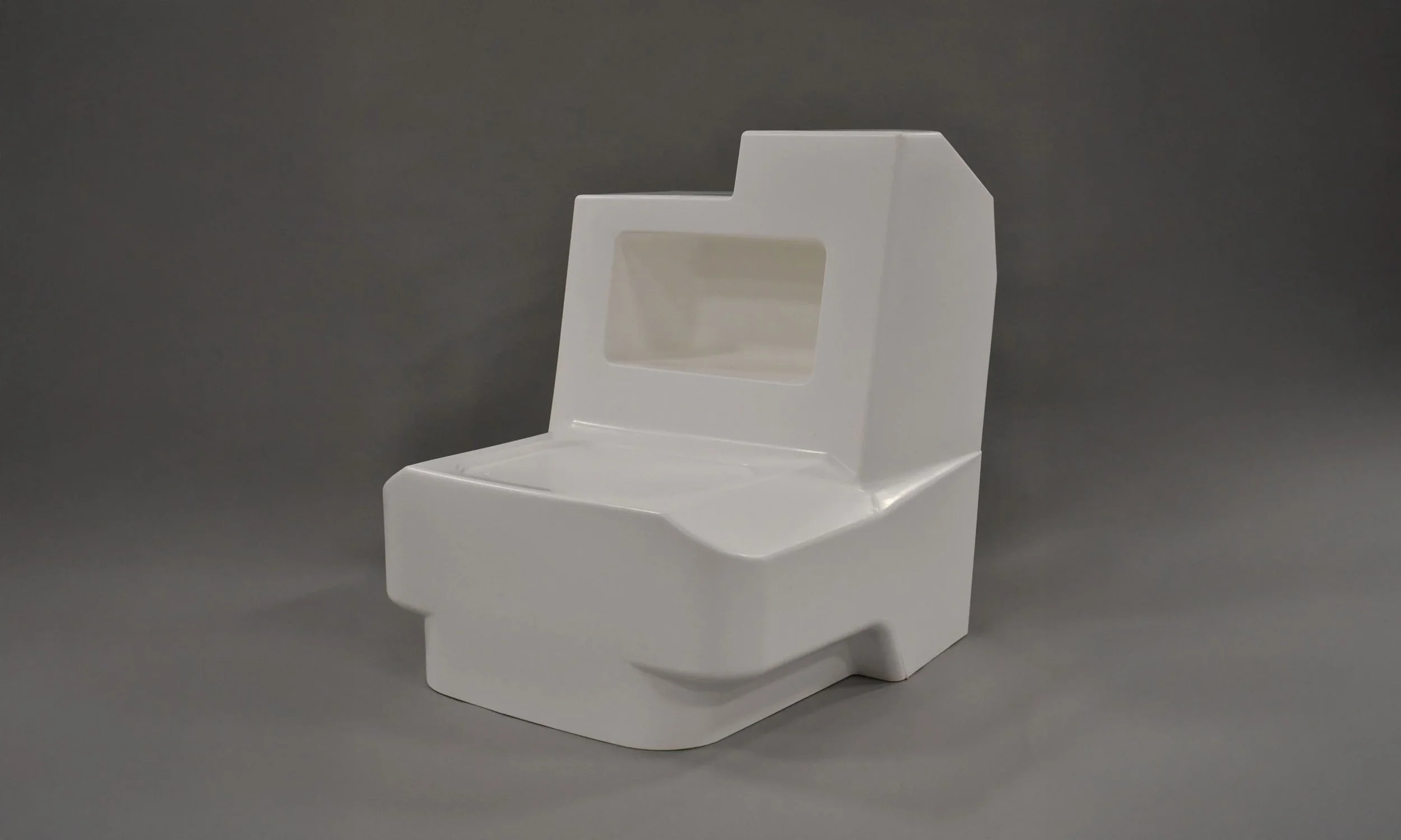 A white plastic miniature toilet model against a gray background.