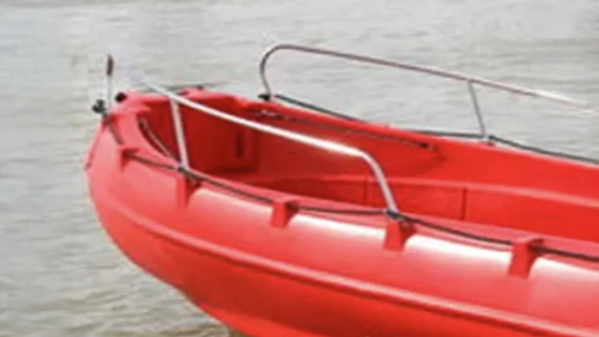 Red inflatable boat floating on water.
