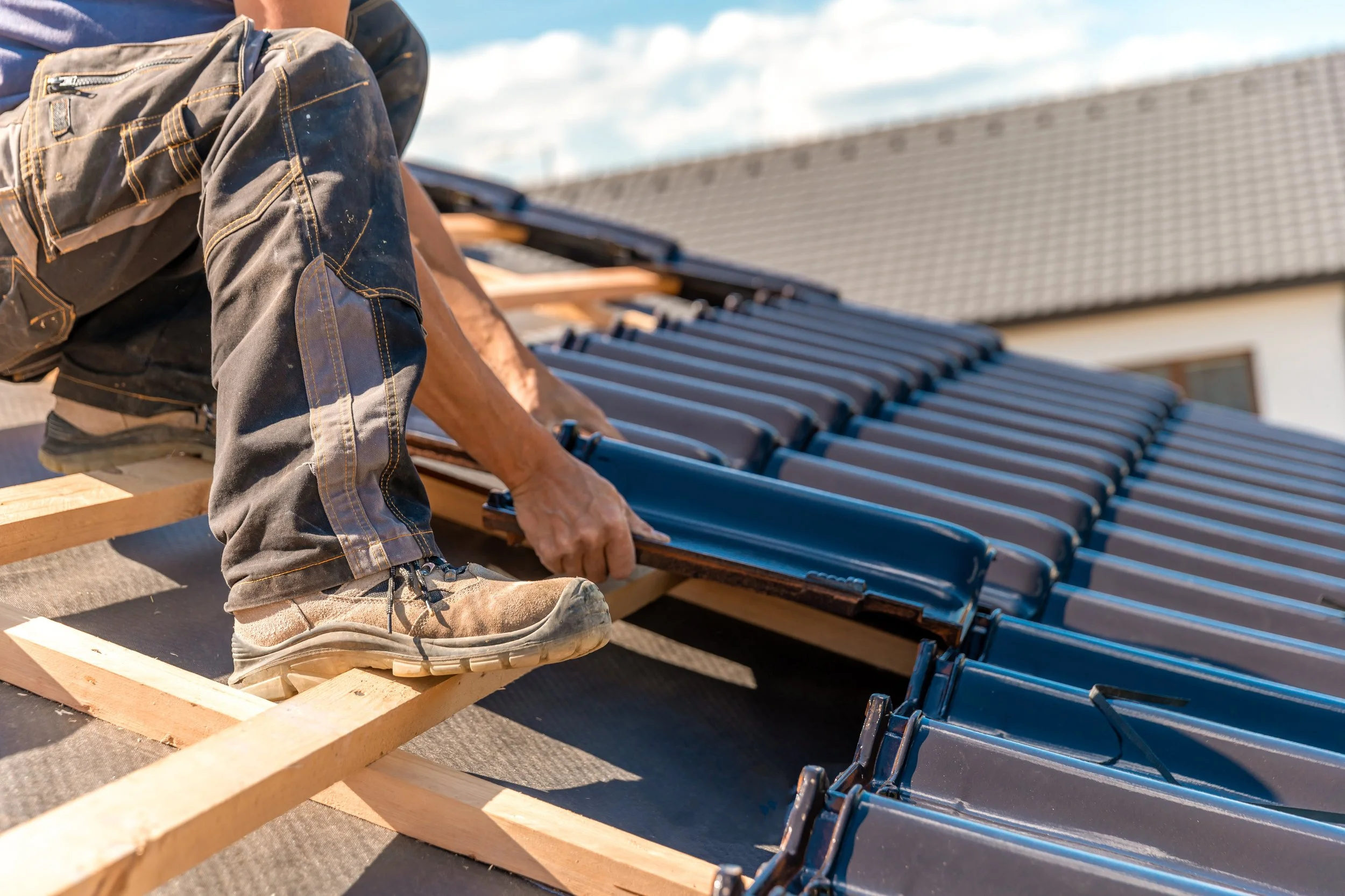 Roofer setting tiles on a residential roof