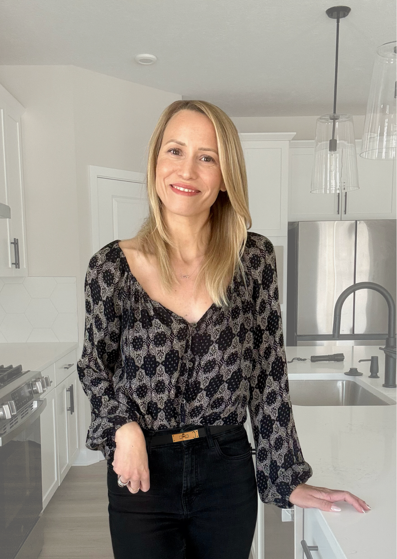 The Interior Designer, a blonde woman standing in the kitchen.