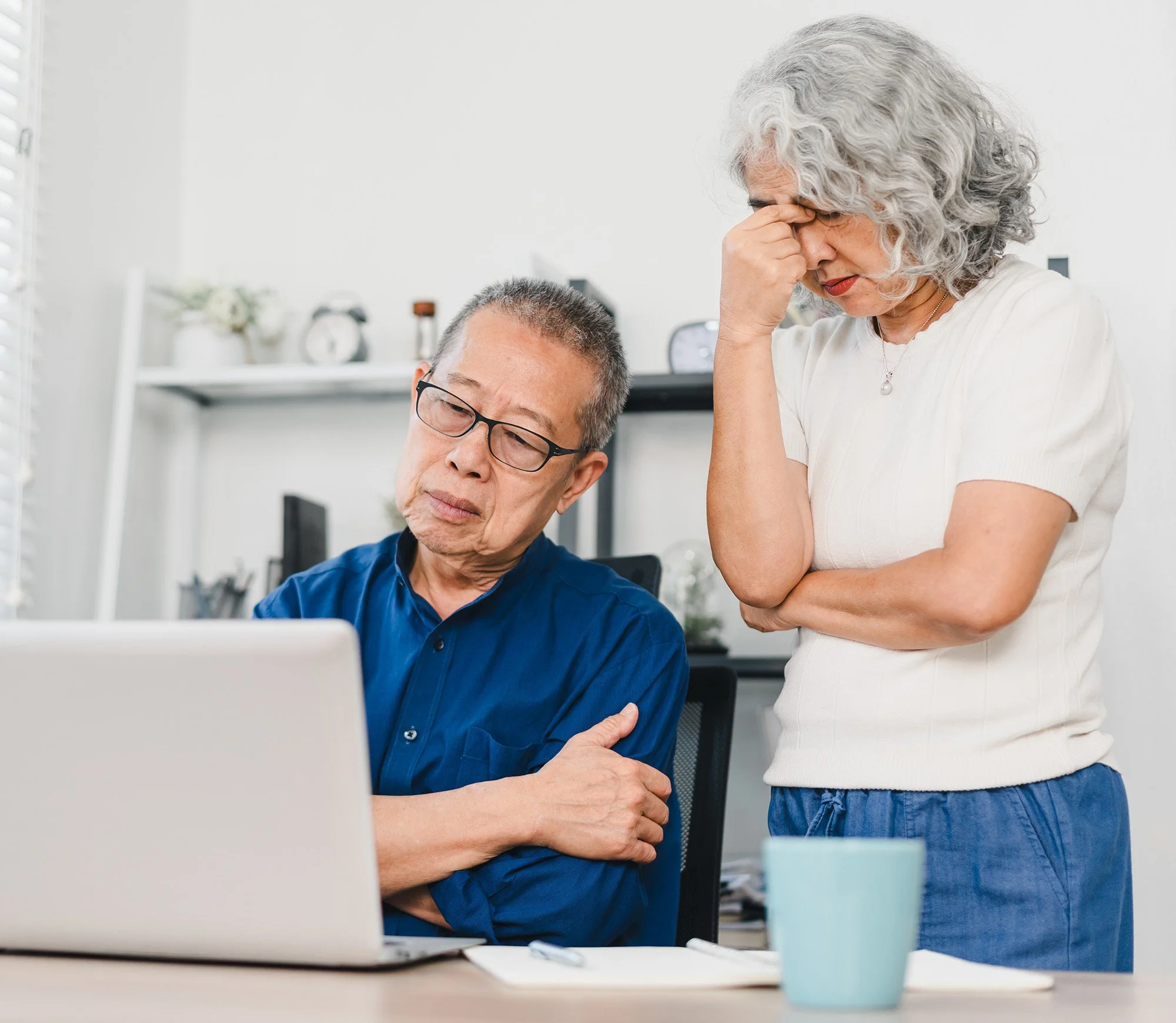 Frustrated middle-aged couple looking at their laptop
