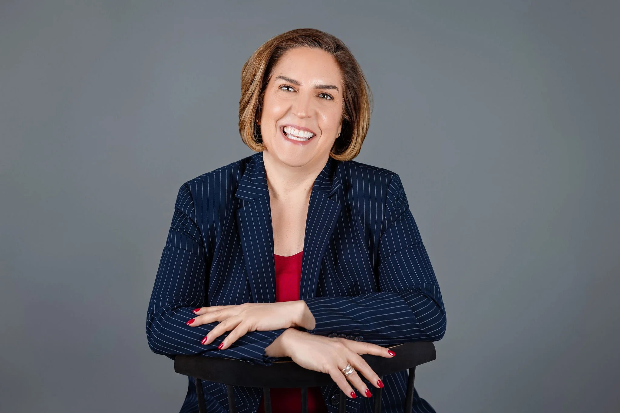 Kara Curtis smiling headshot on a dark gray background